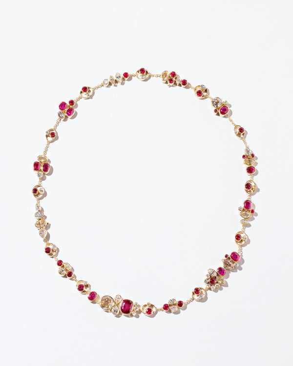 Diamond & Ruby Cluster Necklace laying flat on surface