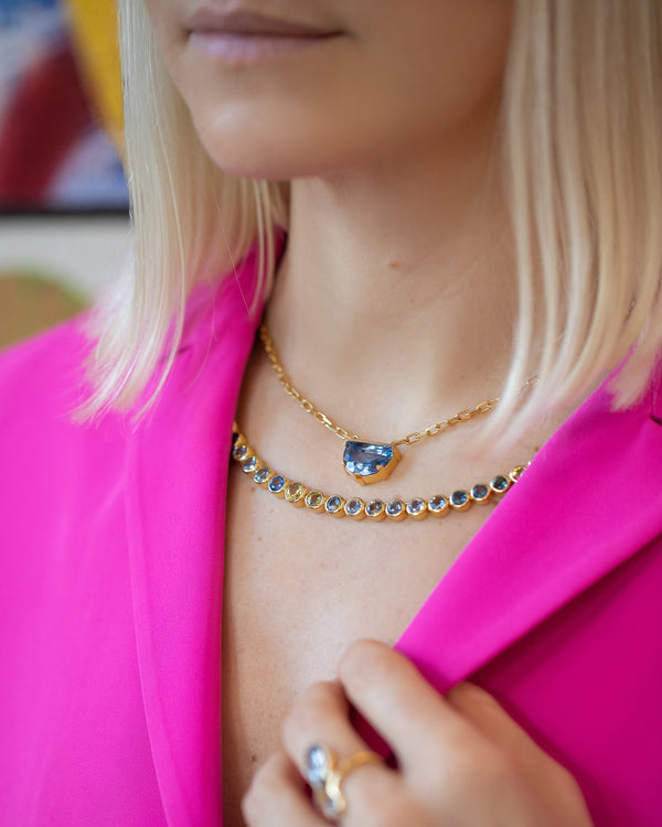 Photo model wearing a magenta jacket with the the Hologram and  Reverence Necklace.