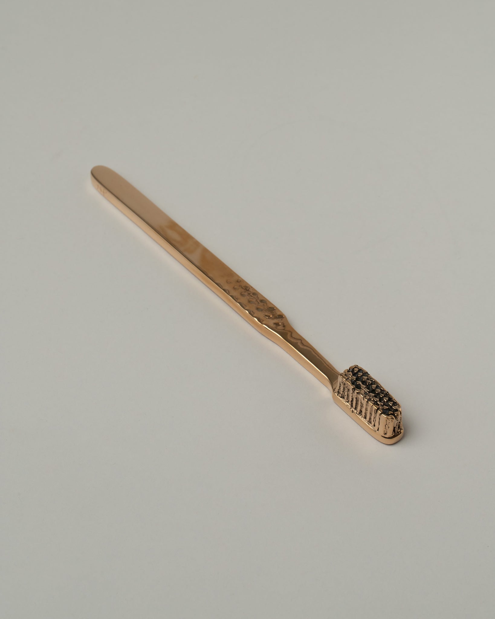 Pearce Objects Bronze Toothpaste Tube on light color background.