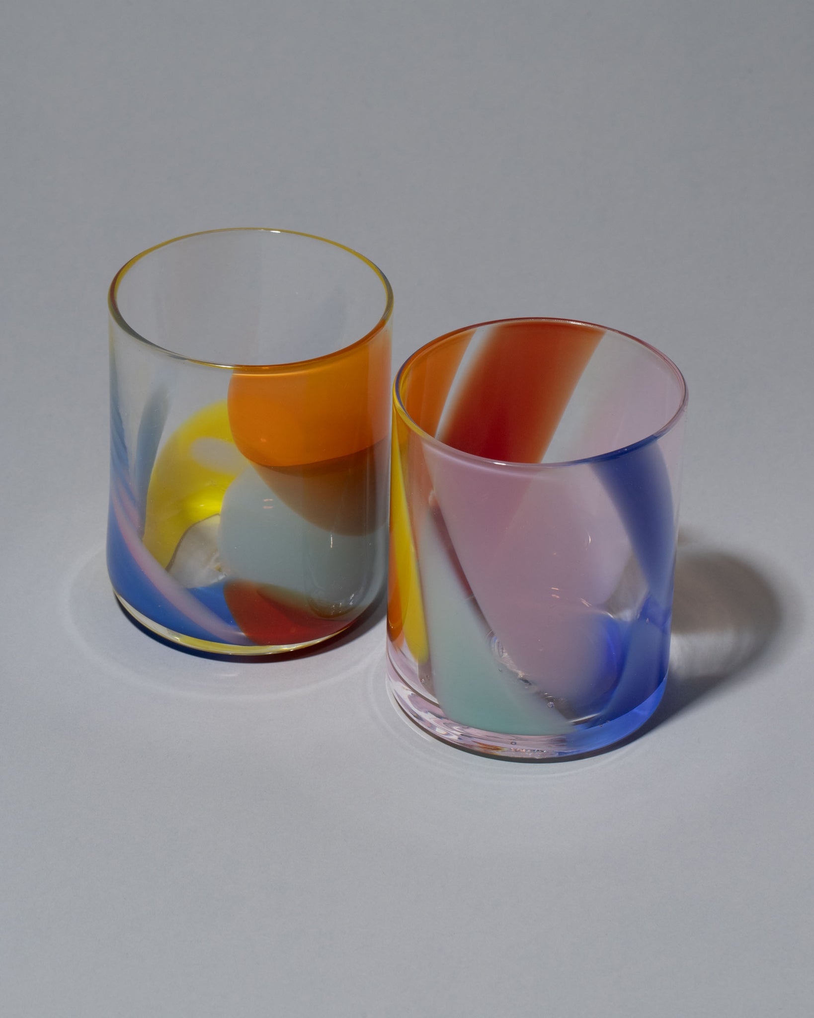 Group image of Bow Glassworks Tutti Fruitti Splash Cup on light color background.