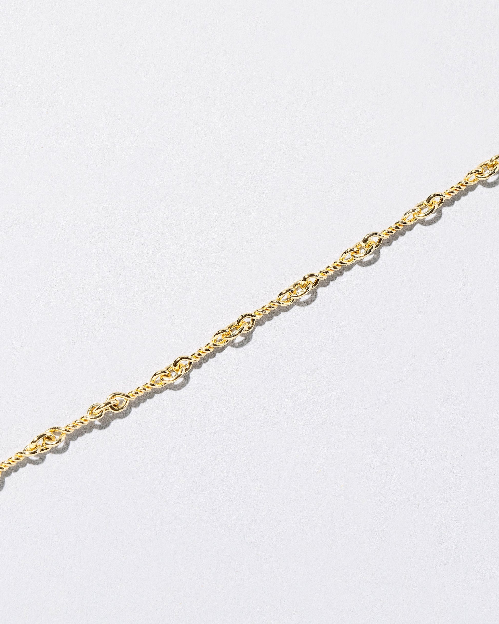Closeup detail of the Twisted Chain Bracelet on light color background.