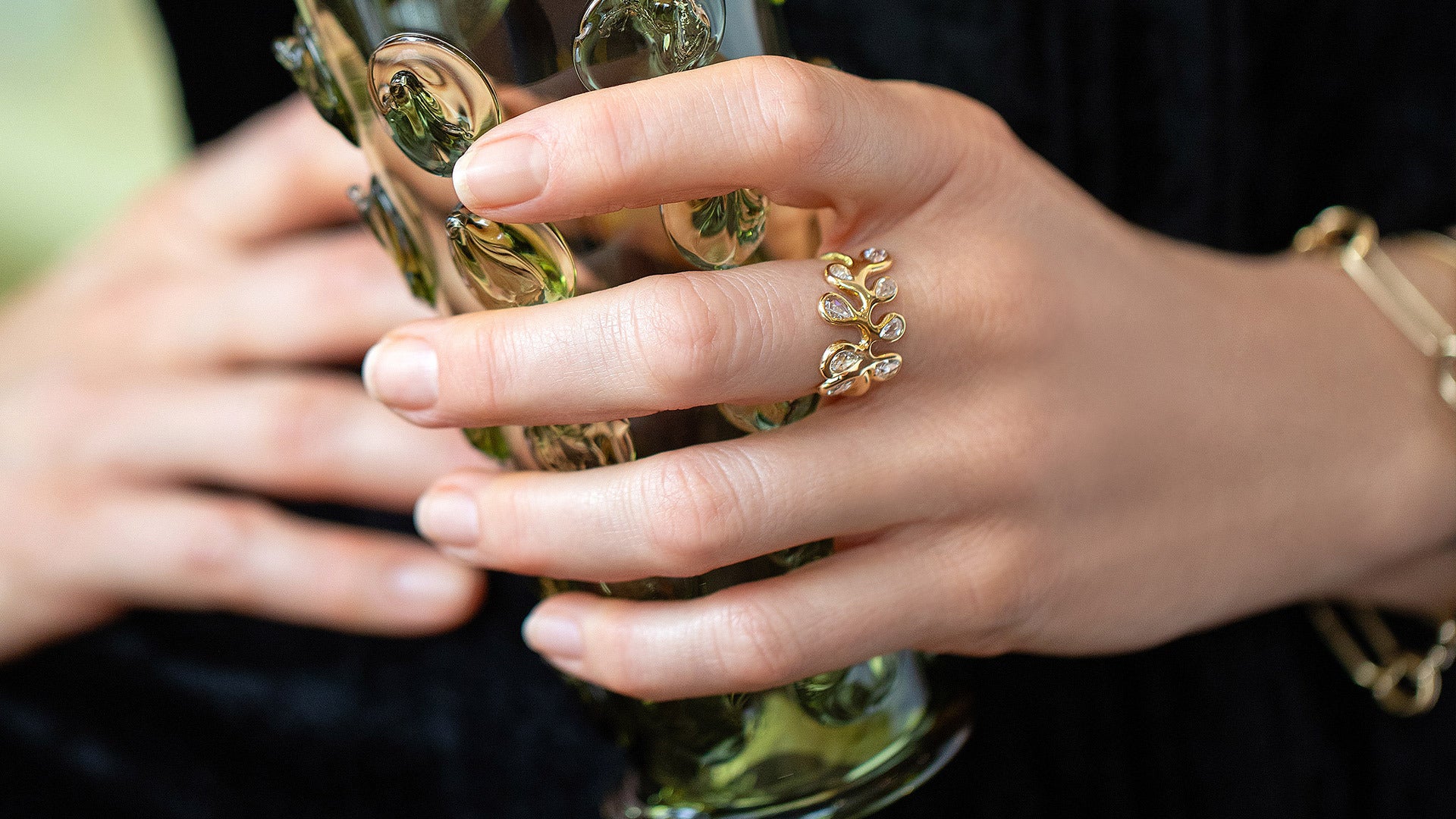 Closeup details of the Palm Ring on model holding the Bollenglass Design Green Small Tumbler.