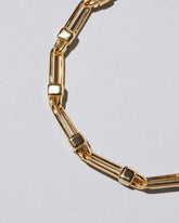 Closeup detail of the Lightweight Half Loop Link Bracelet on light color background.