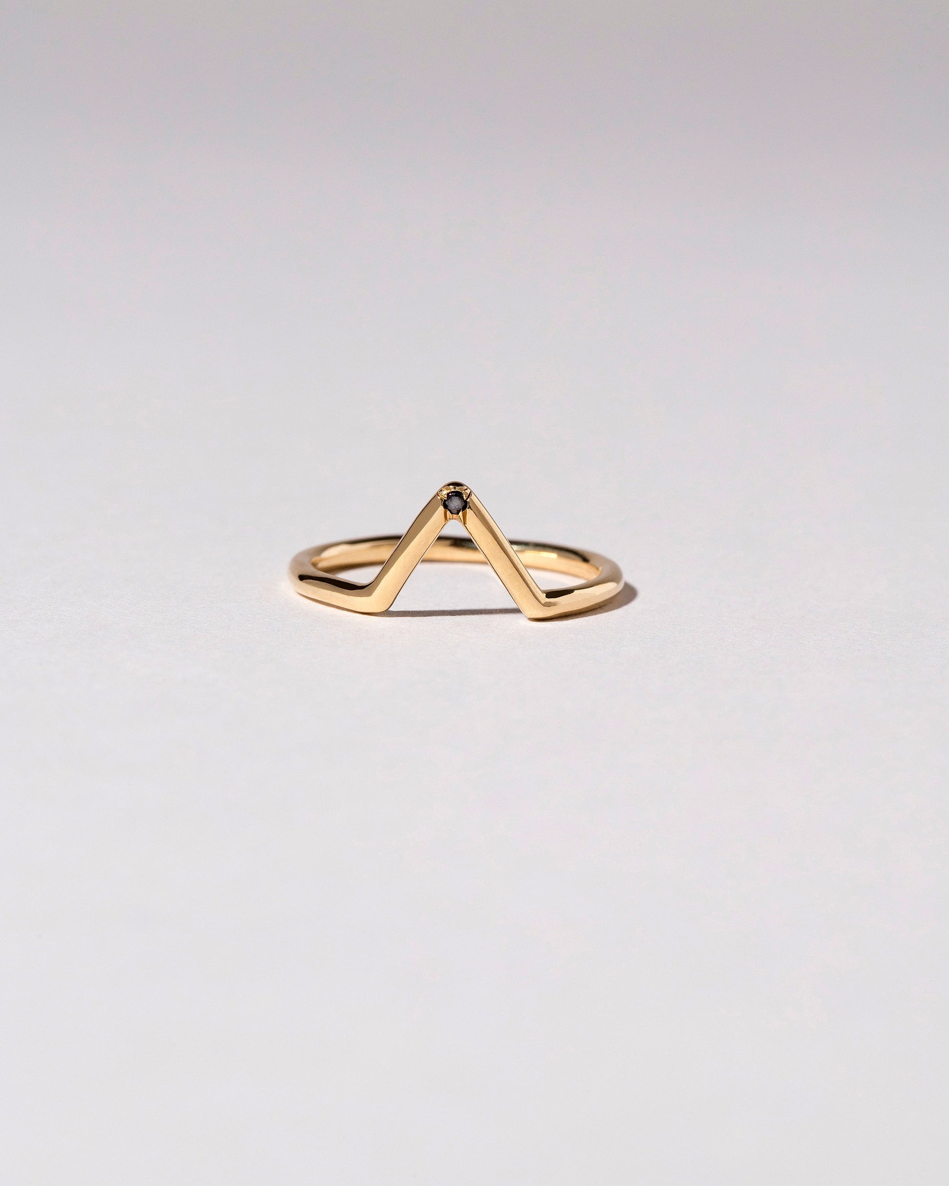 Gold Single Burnish-Set Black Diamond Triangle Band on light color background.