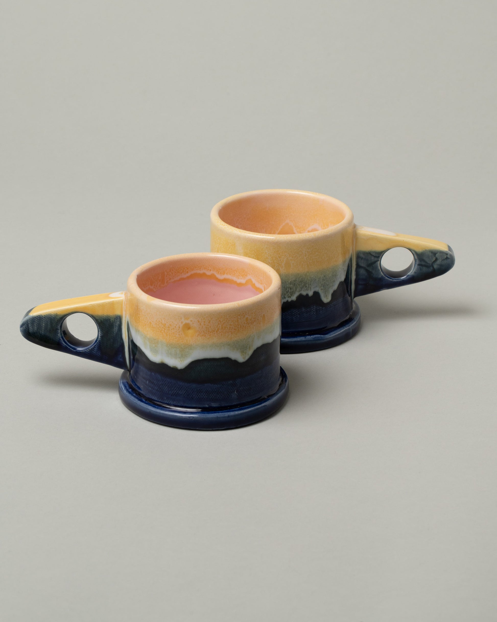 Group of Echo Park Pottery by Peter Shire Indigo Double Dip Mugs on light color background.