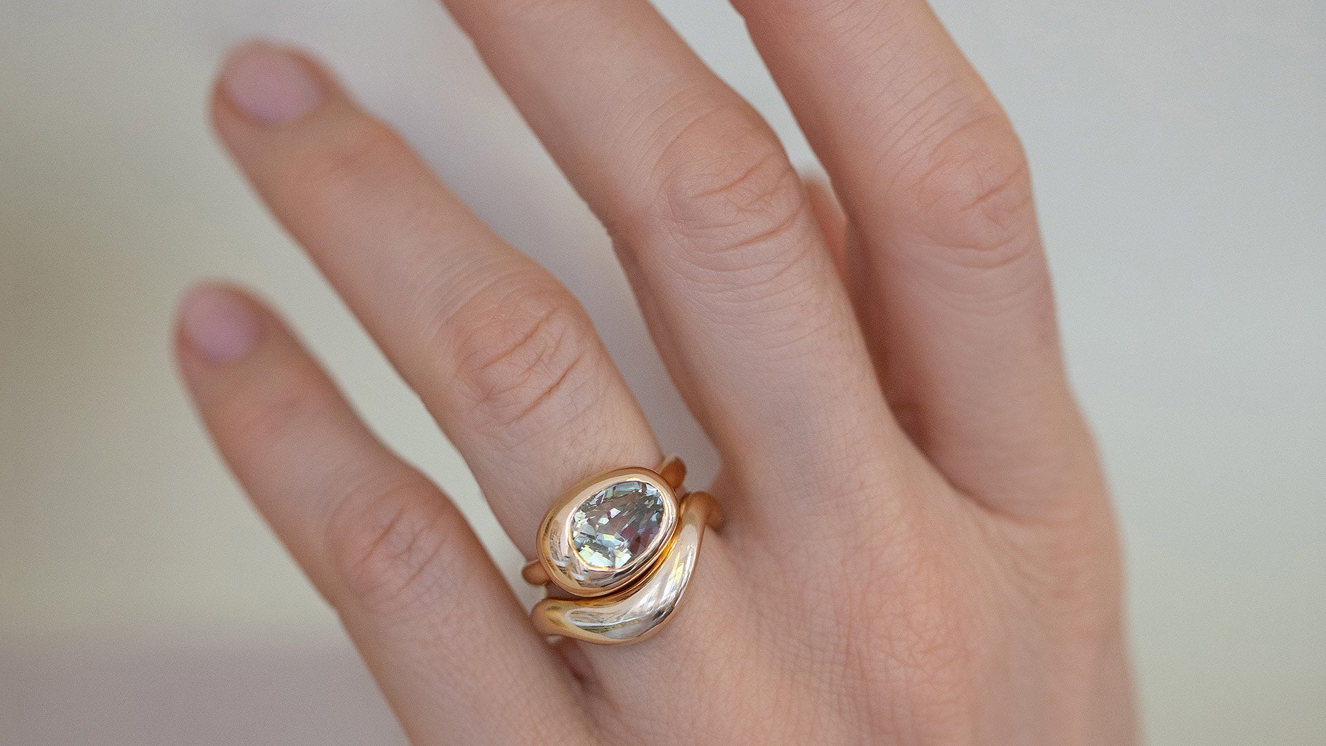 Photo of model's hand wearing the Grand Align Ring with a gold band