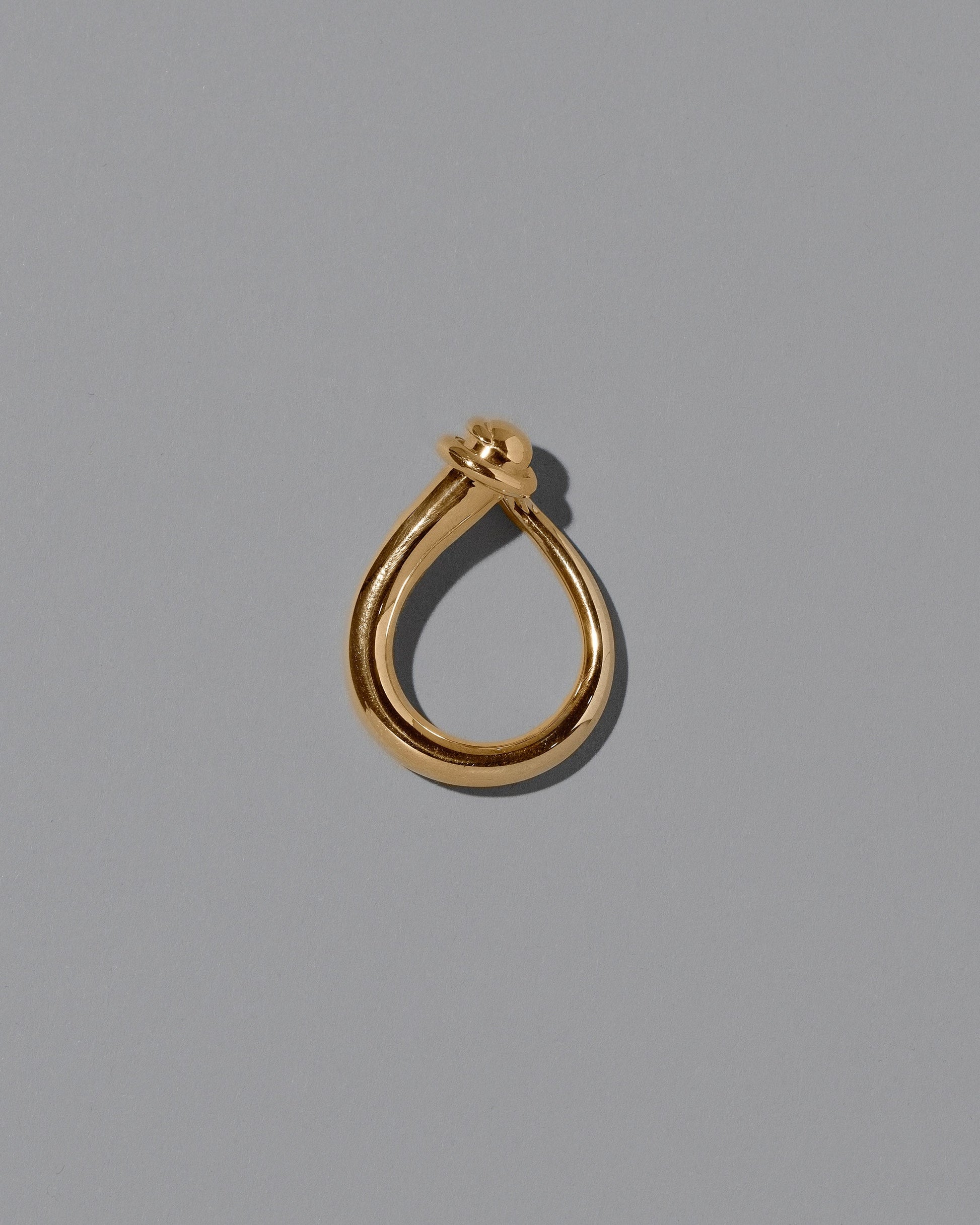 View from the side of the CRZM Gold Boulder Ring on light color background.