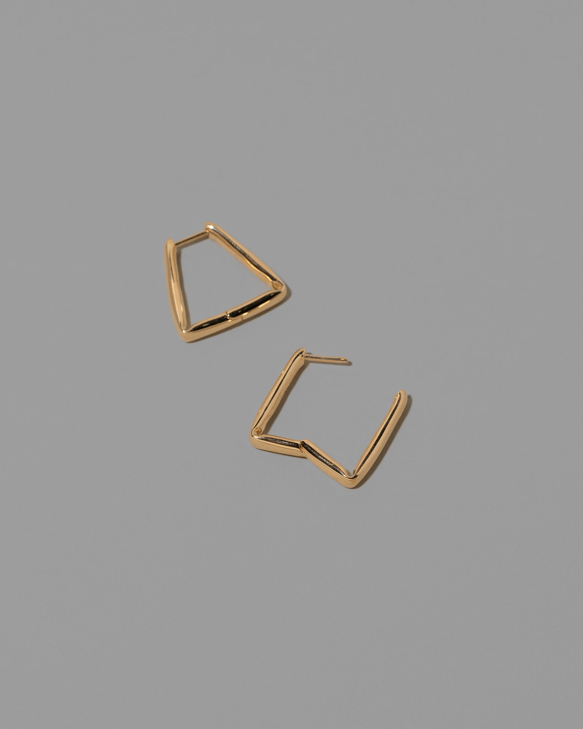 Detail view of the Gold Bend Hoop Earrings on light color background.