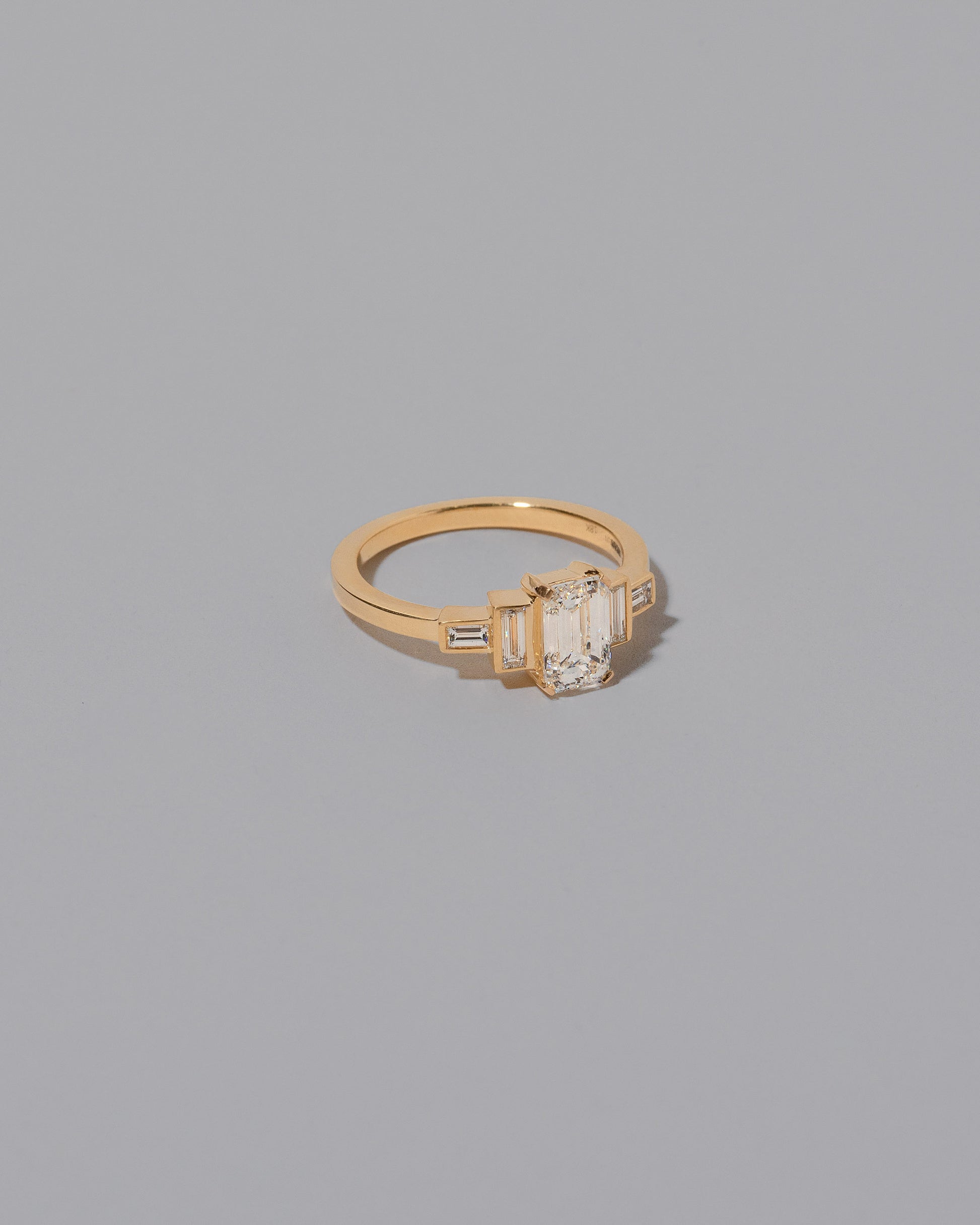 View from the side of the Diamond Assertion Ring on light color background.