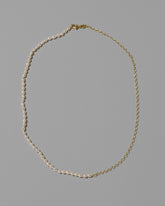 Half Oval Chain & White Seed Pearl Necklace on light color background.