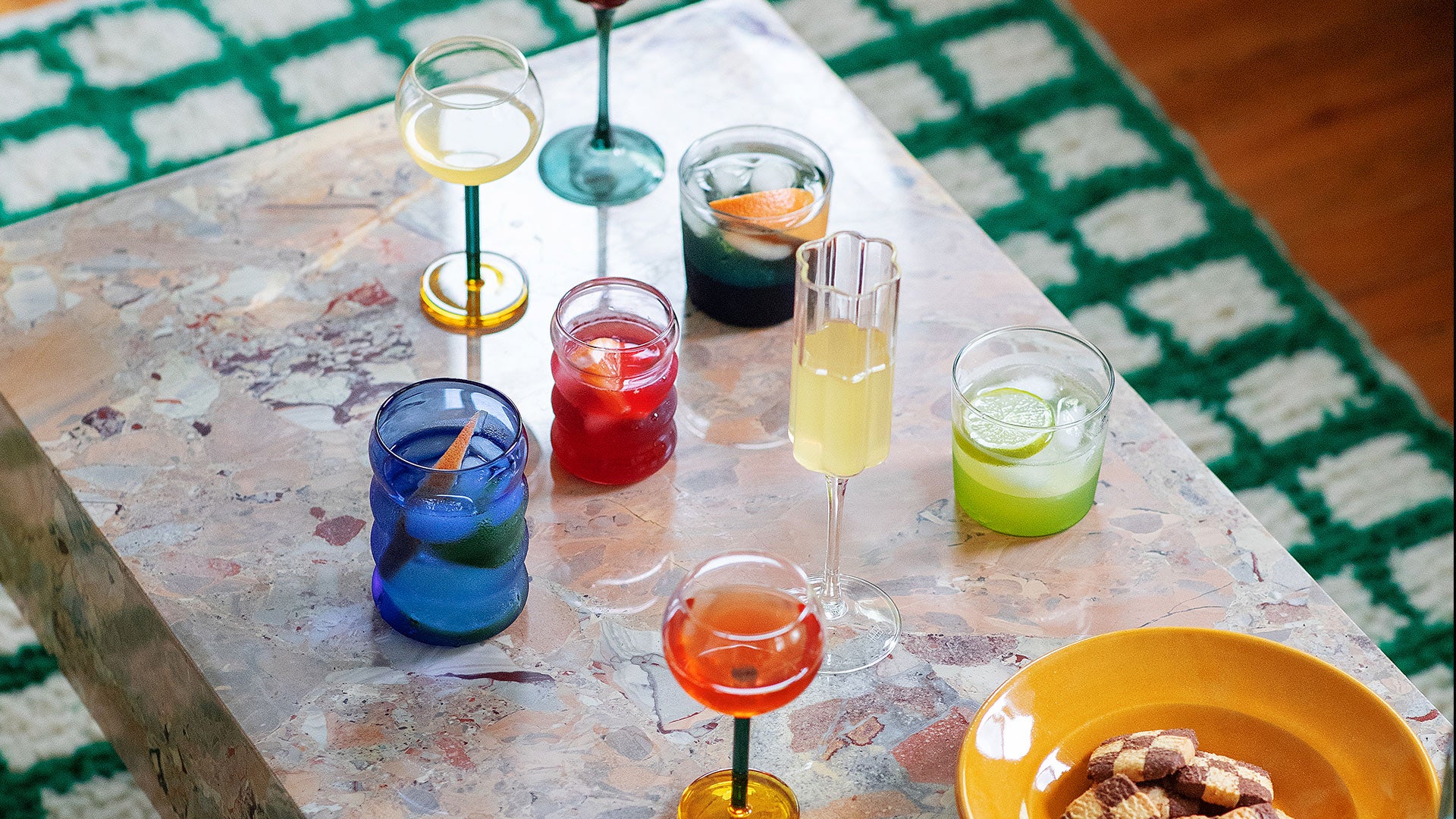 Editorial photo a mix of colorful glassware by Sophie Lou Jacobsen, Fazeek, and Ichendorf Milano on a marble table.