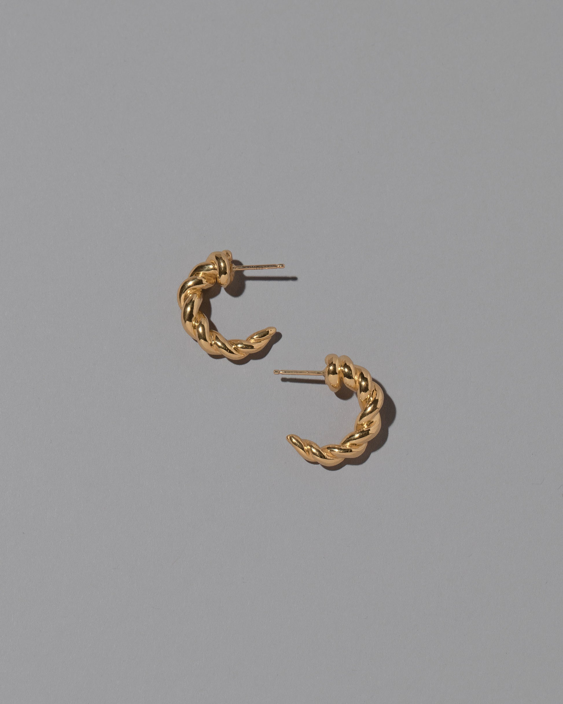 CRZM Gold Foothill Hoop Earrings on light color background.