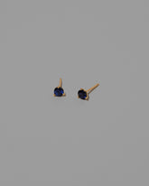 Blue Sapphire Martini Stud Earrings on light color background.