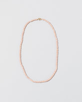 Pink Peony Pebble Seed Pearl Choker Necklace on light color background.