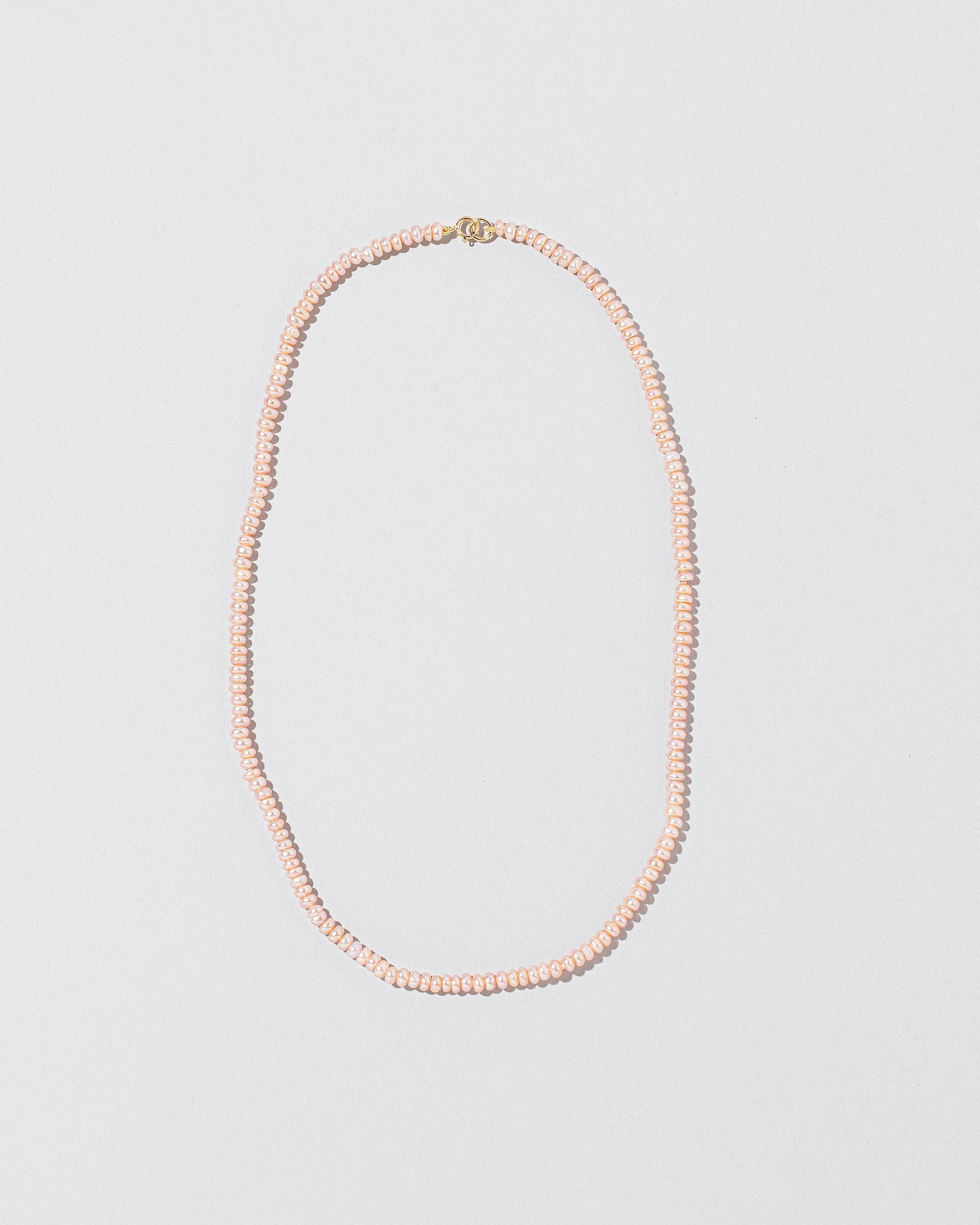 Pink Peony Pebble Seed Pearl Choker Necklace on light color background.