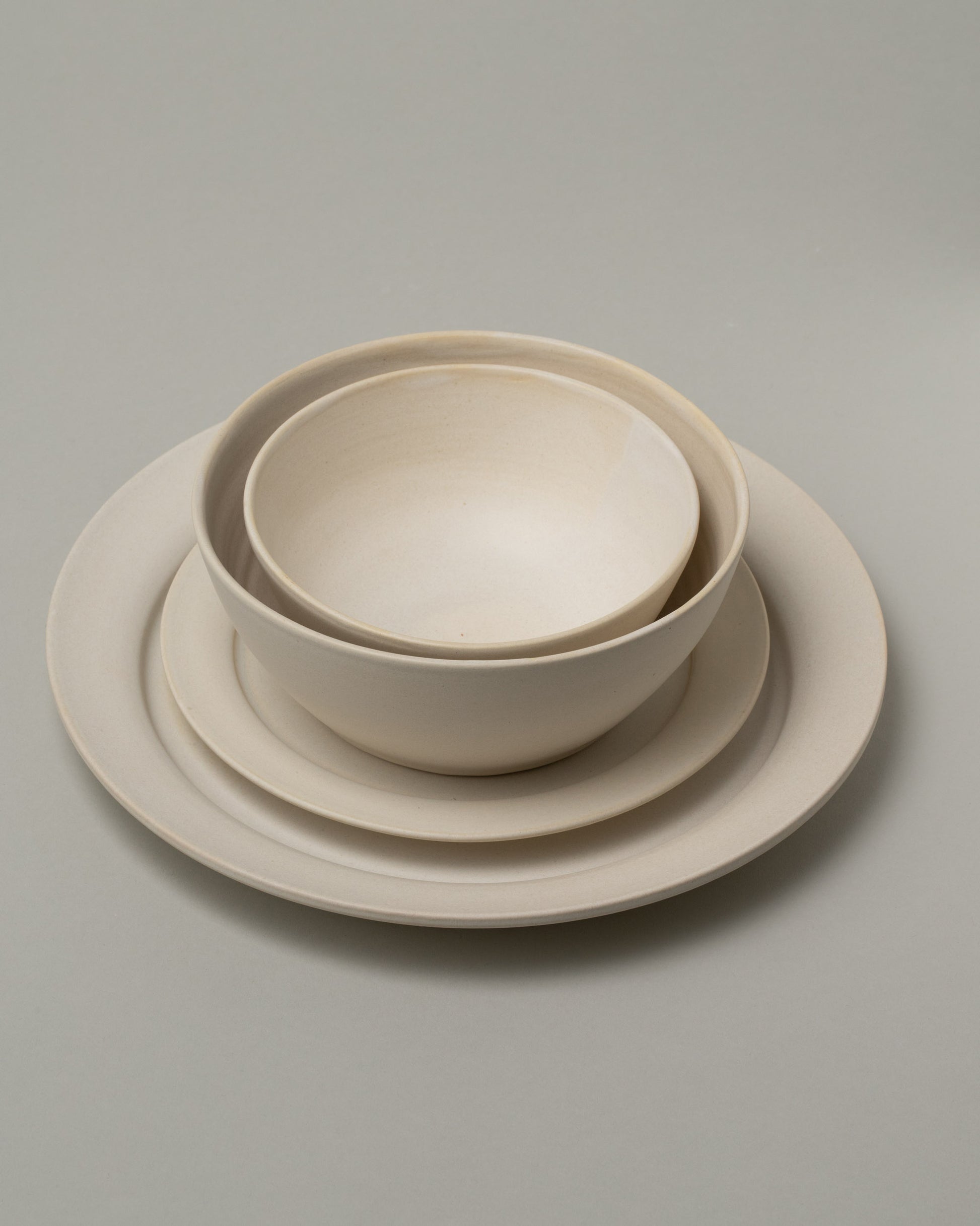 Tracie Hervy Small Bowl, Large Bowl, Salad Plate and Dinner Plate on light color background.