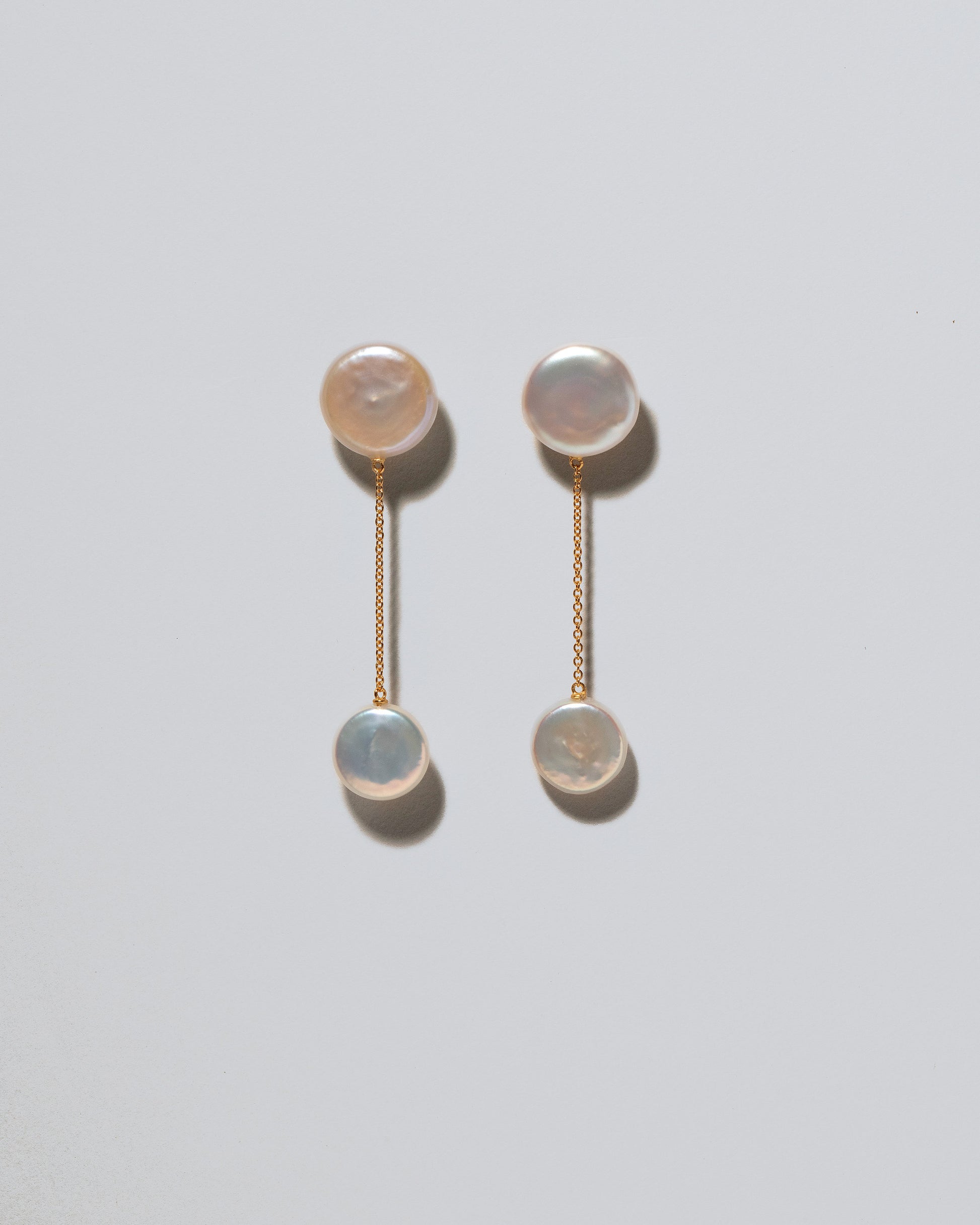 Plover Pearl Earrings on light color background.