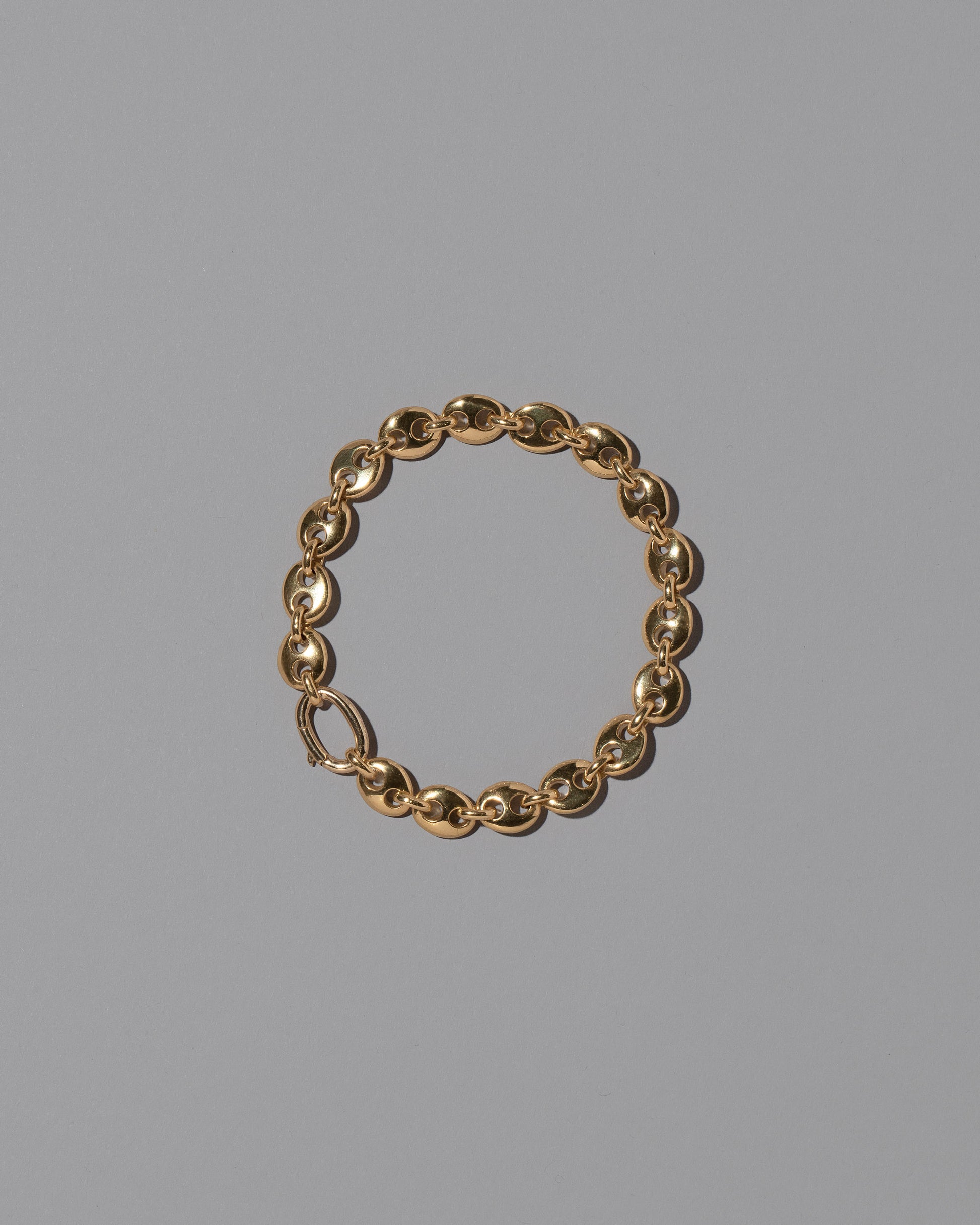 CRZM Gold Mini Bedrock Bracelet on light color background.