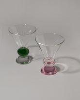 Group of Sophie Lou Jacobsen Green & Clear and Sophie Lou Jacobsen Clear & Pink Totem Glasses on light color background.