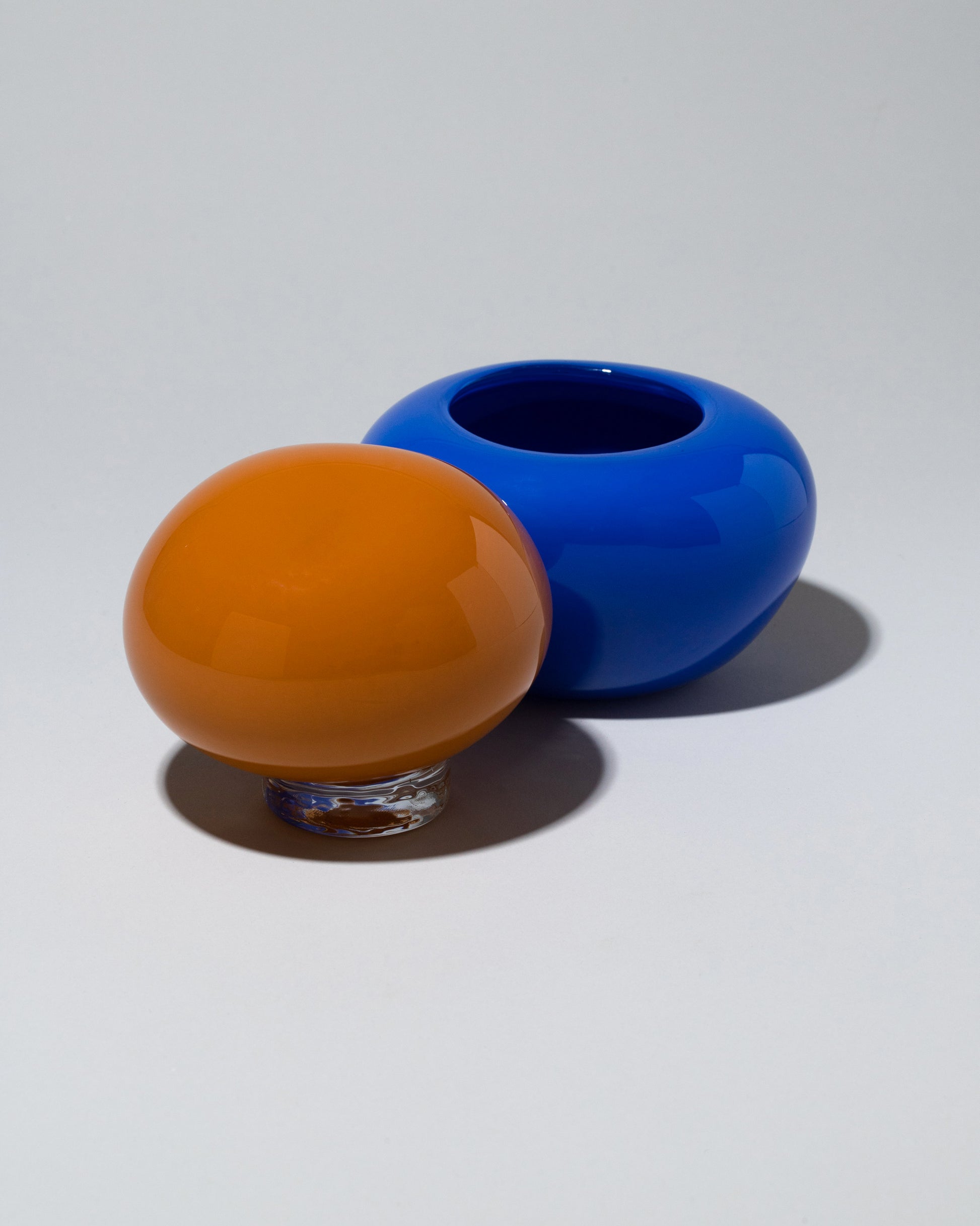 Detail view of the Helle Mardahl Orange & Blue Lollipop Bonbonniere on light color background.