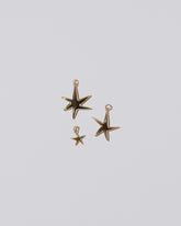 From left to right: A Verve Six Point Star Charms, as well as the small and large Verve Five Point Star Charms on light color background.