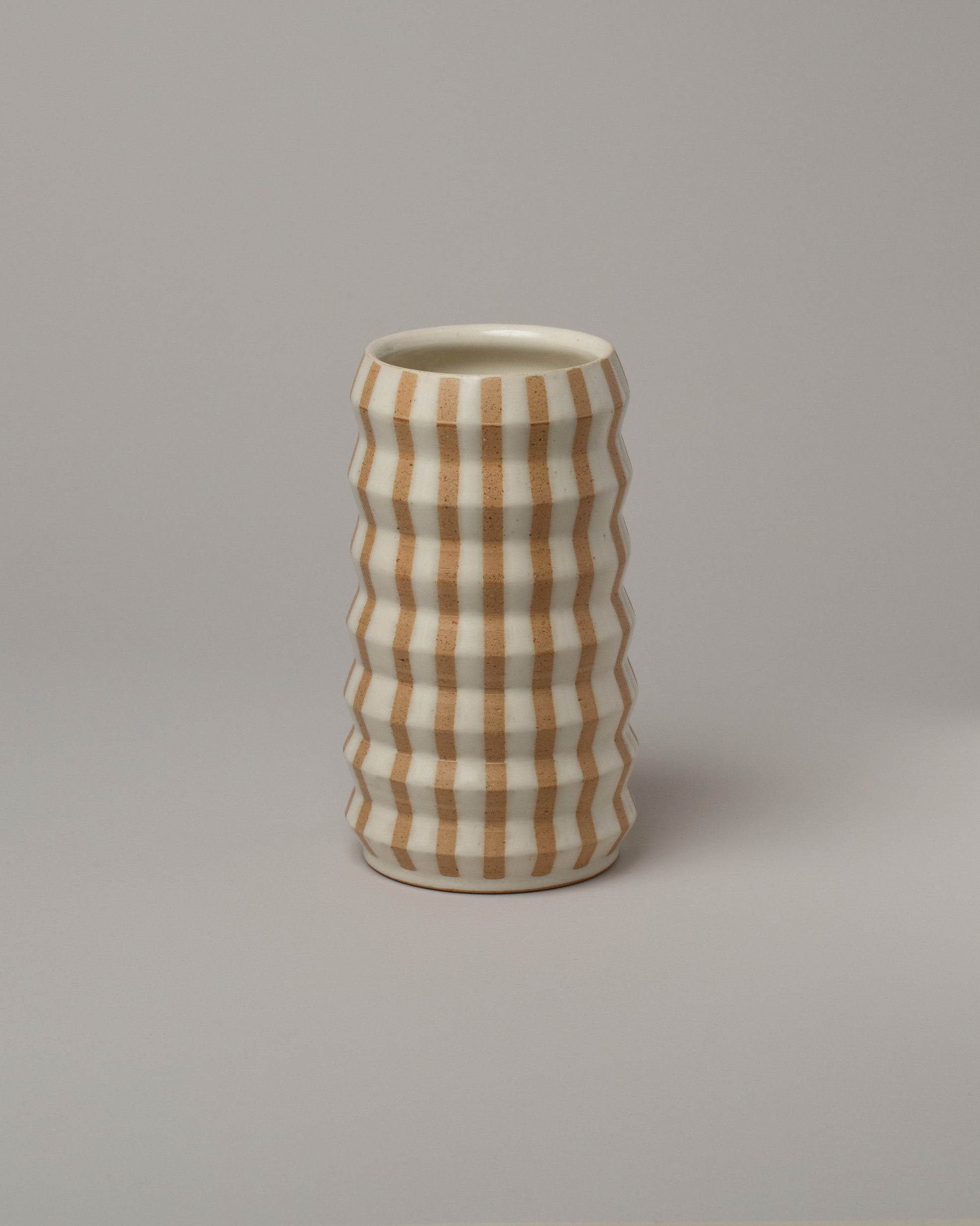 Jeremy Ayers White Striped Accordion Vase on light color background.