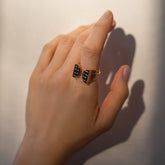 product_details::Vintage Mauboussin Paris Blue Sapphire Bow Ring on model.