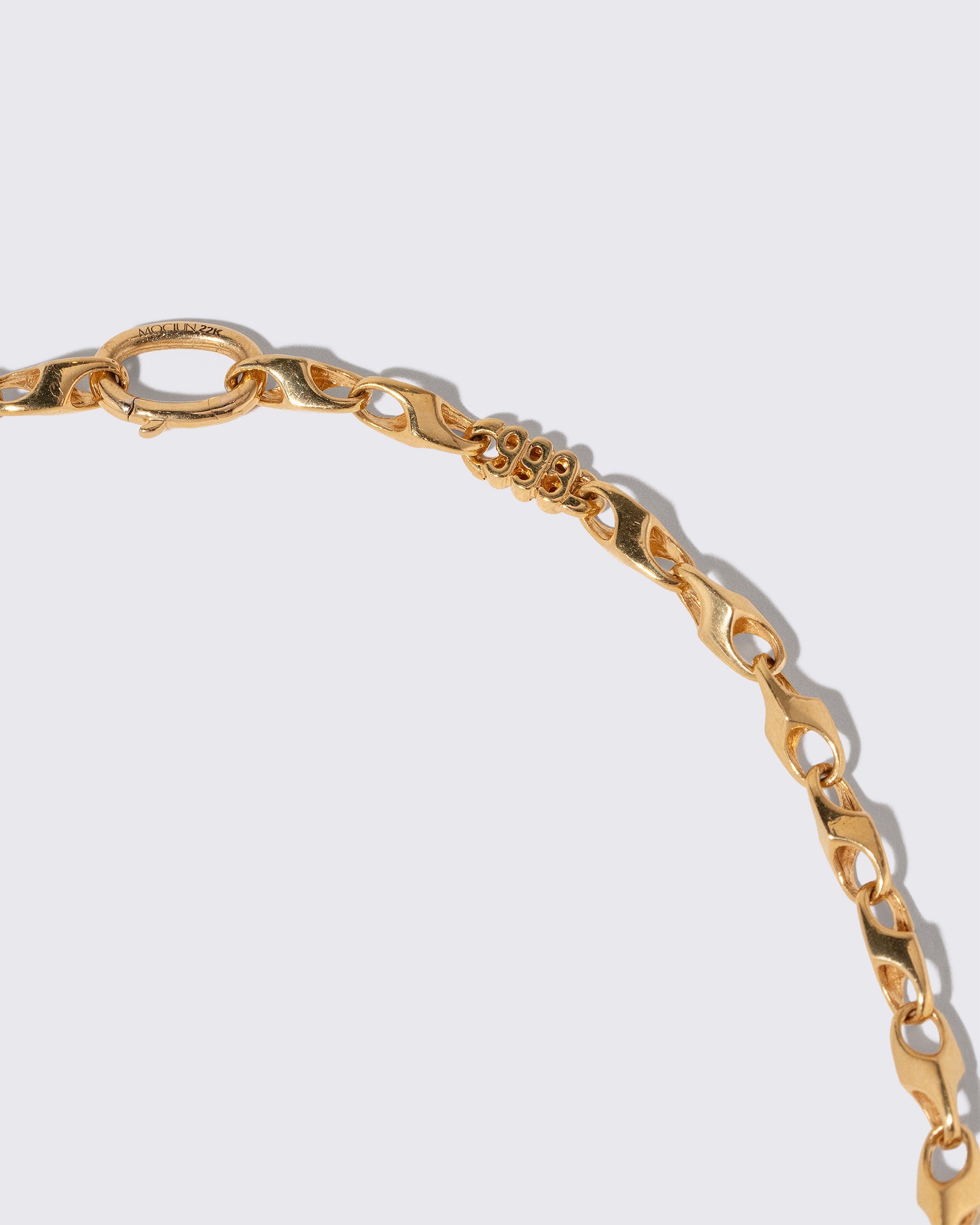Closeup details of the Vintage Triple Nine Chain Necklace on light color background.