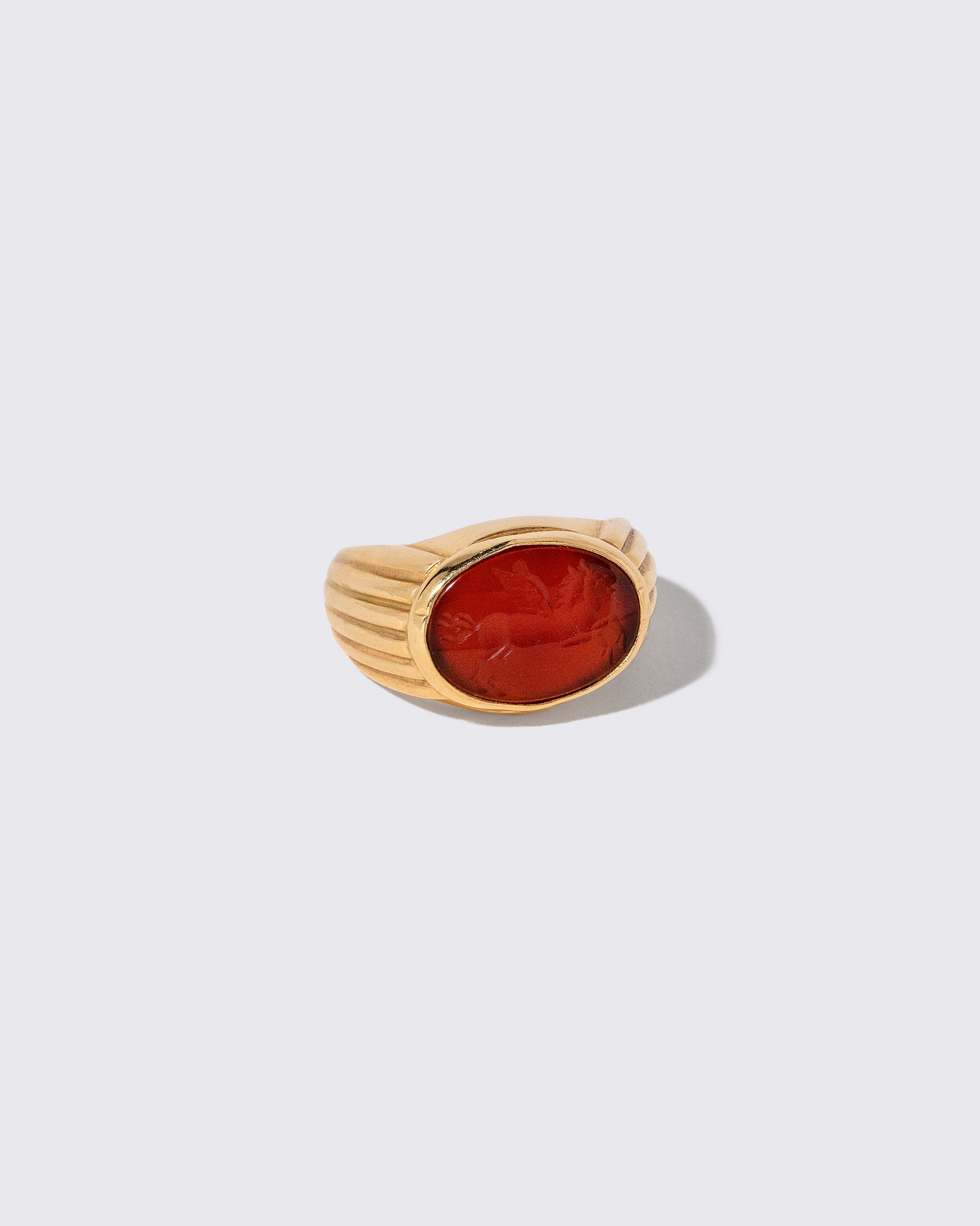 View from the side of the Vintage Bvlgari Carnelian Pegasus Intaglio Ring on light color background.