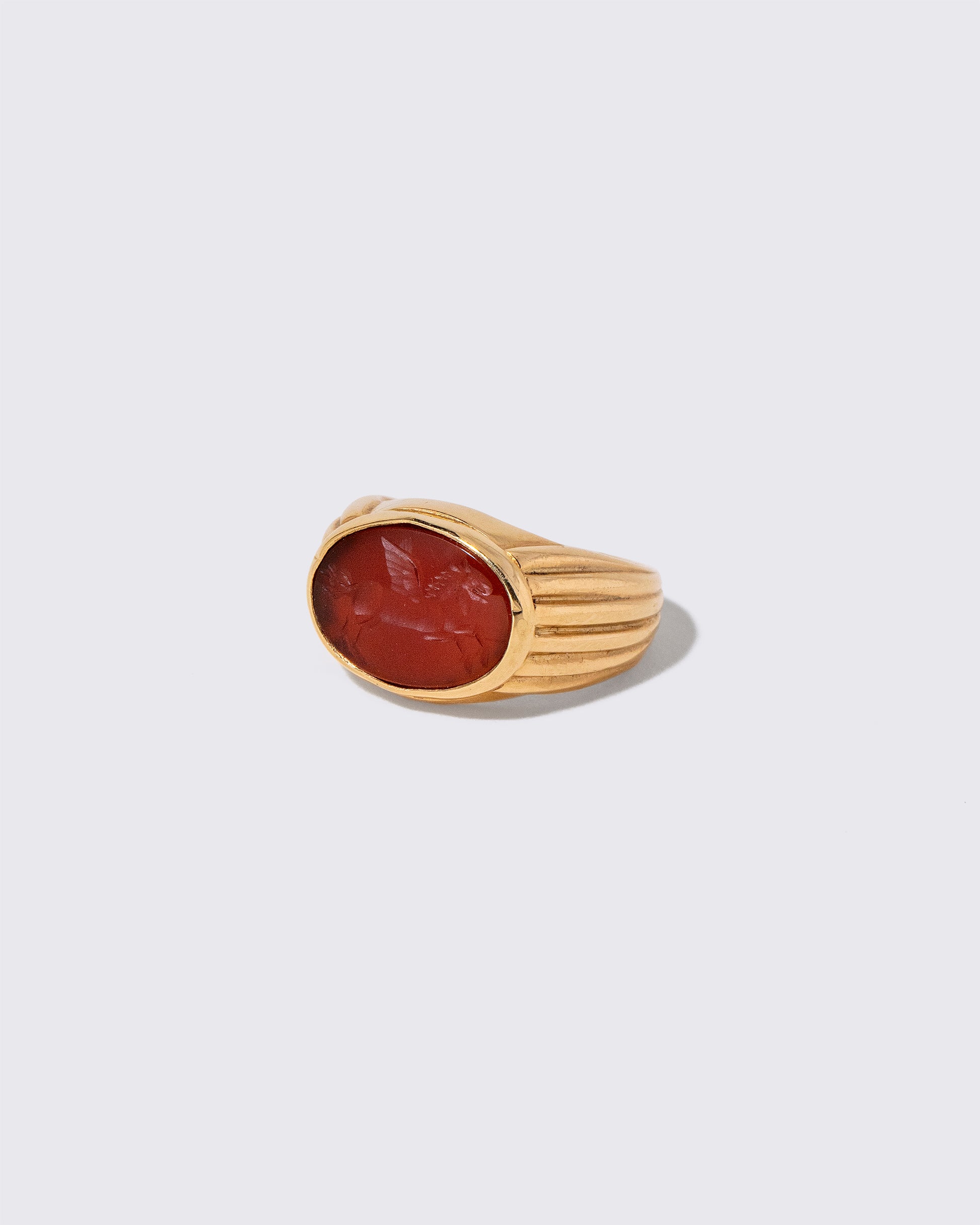 View from the side of the Vintage Bvlgari Carnelian Pegasus Intaglio Ring on light color background.