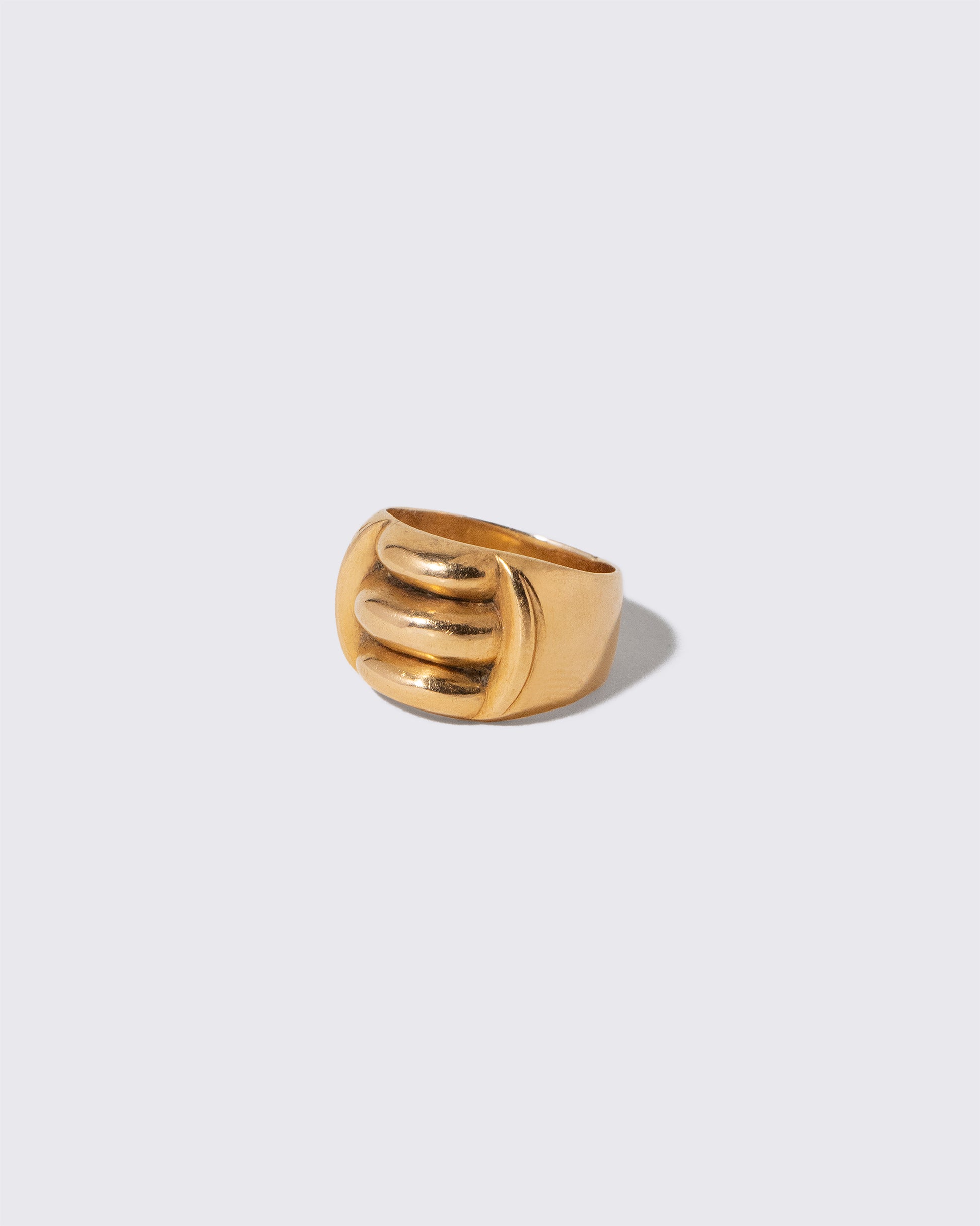 View from the side of the Vintage Gold Gadroon Ring on light color background.