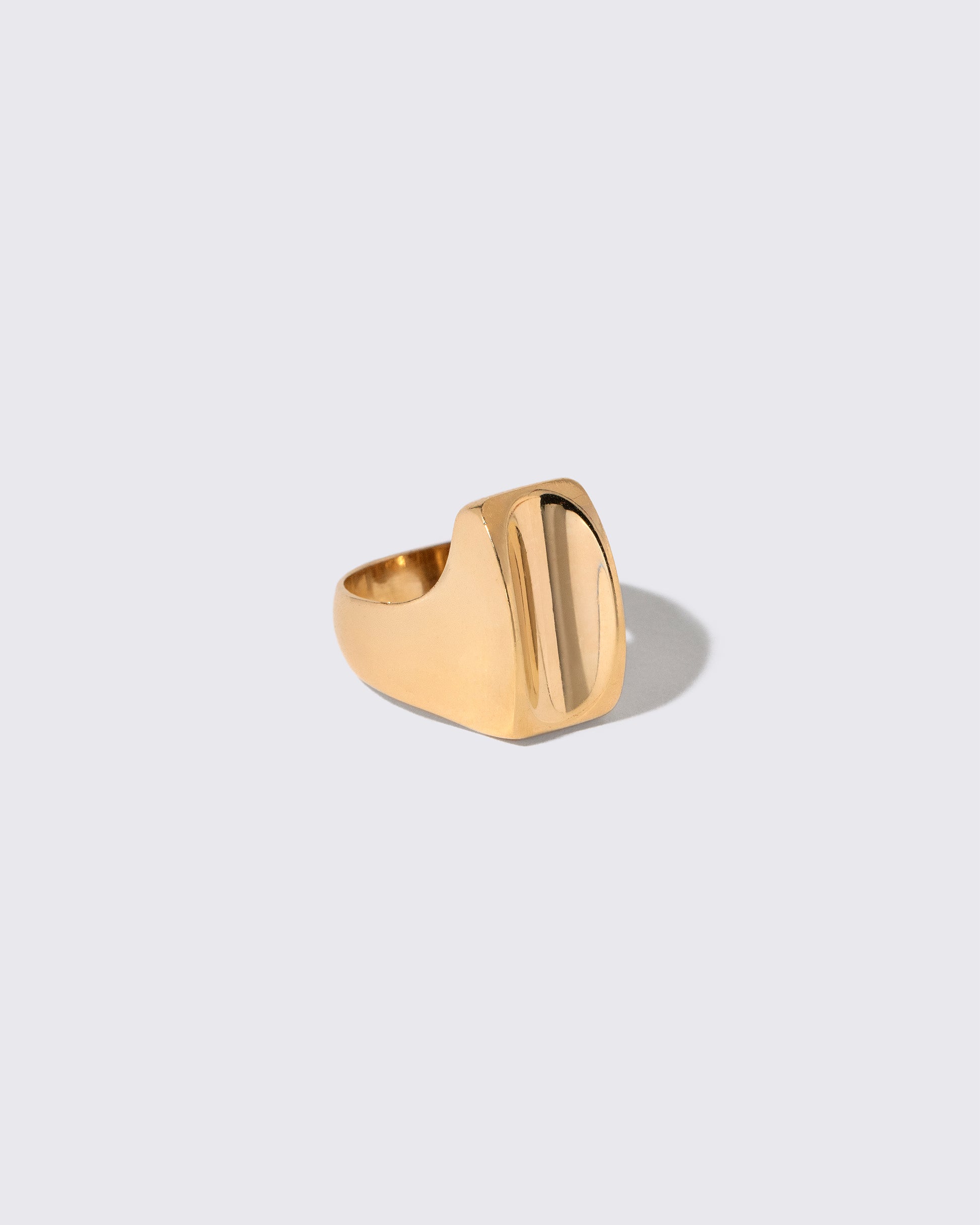 View from the side of the Vintage Gold Saddle Ring on light color background.