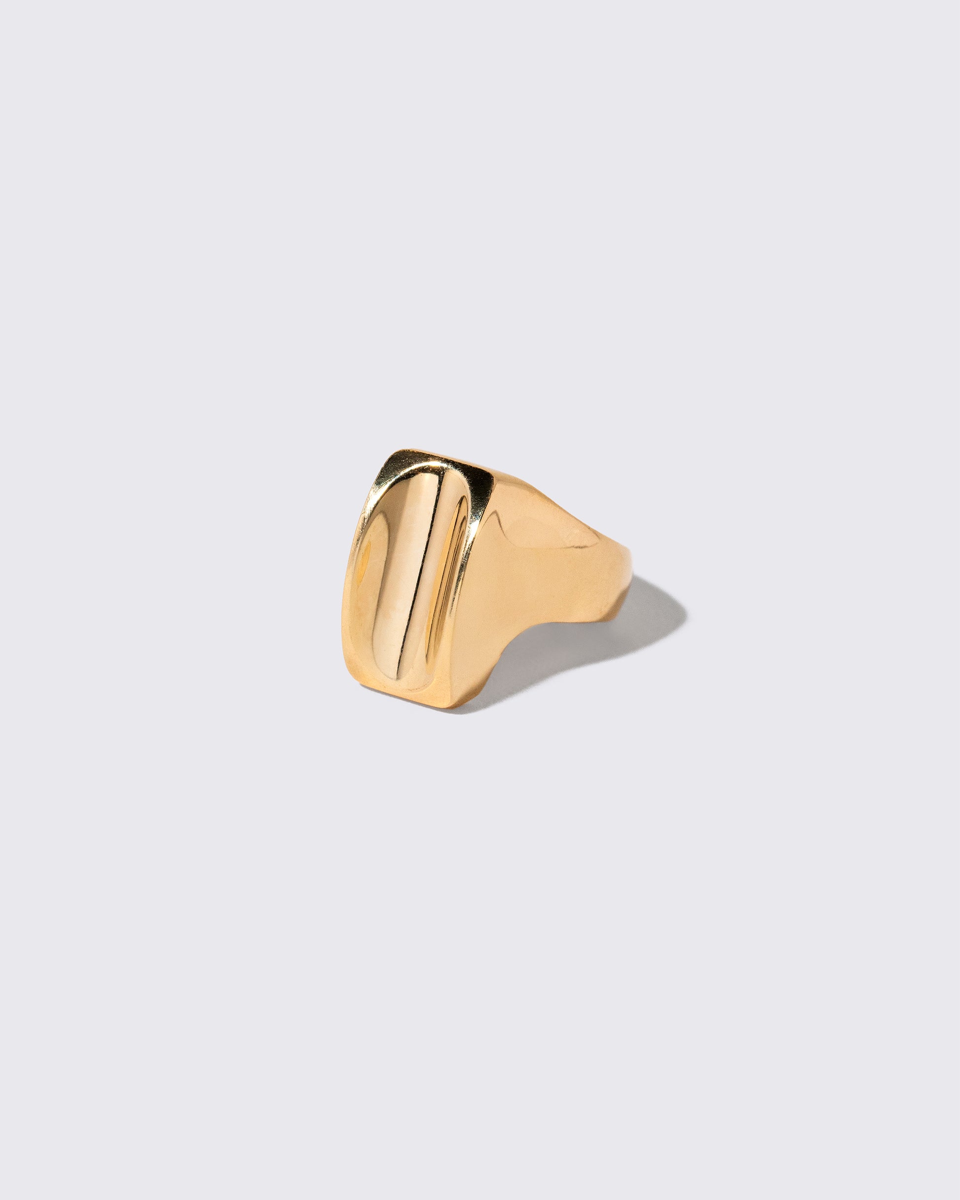 View from the side of the Vintage Gold Saddle Ring on light color background.