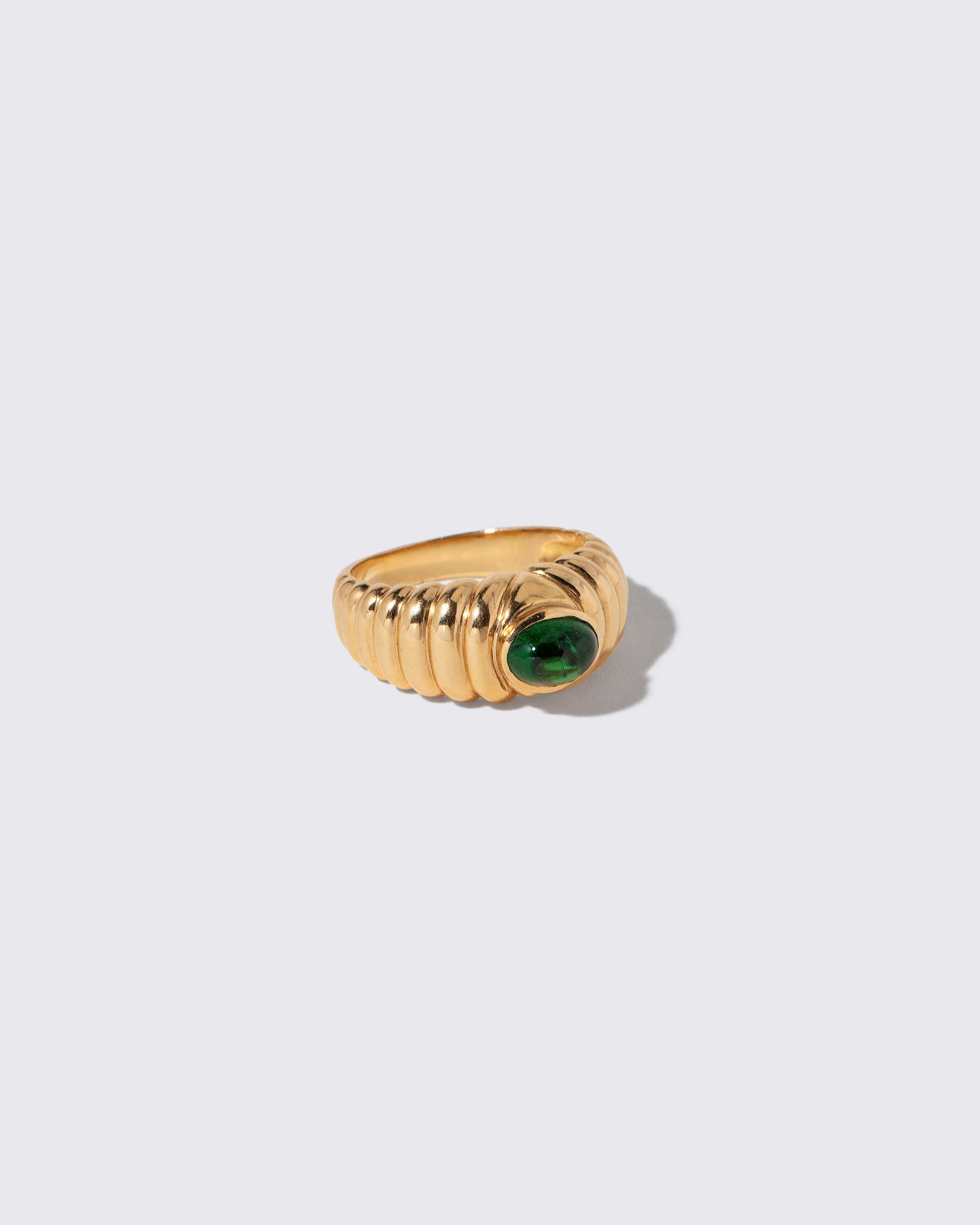 View from the side of the Vintage Ribbed Peridot Ring on light color background.