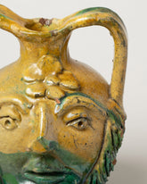 Closeup details of the Apotropaia Head Handled Vessel on light color background.