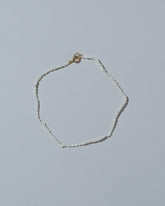 Samples & Imperfects White Petite Oval Seed Pearl Bracelet on light color background.