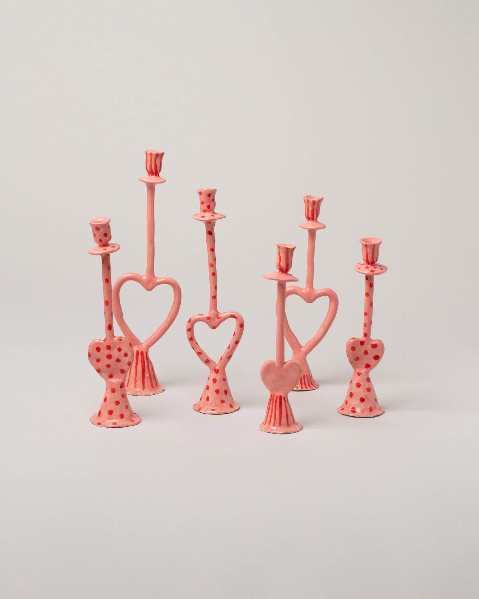 Group of La Romaine Editions Heart-Shaped Candle Holders on light color background.