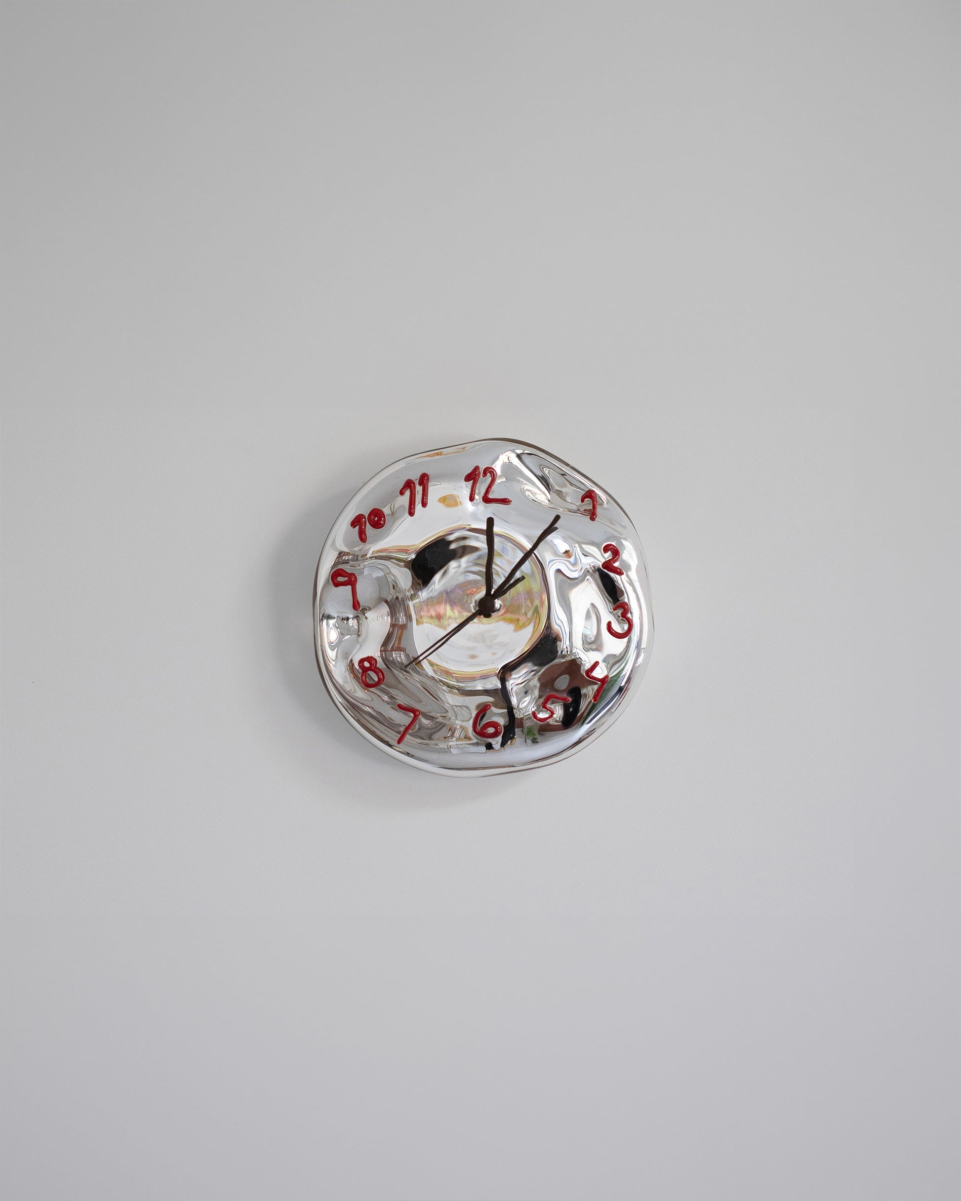 Silje Lindrup Brown Hands Red Glass Wall Clock on light color background.