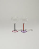 Sophie Lou Jacobsen Twilight: Amber & Lilac + Midnight Blue & Pink Bilboquet Wine Glass Set on light color background.