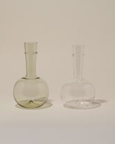 Bollenglass Design Clear Bud Vase and Green Bud Vase on light color background.