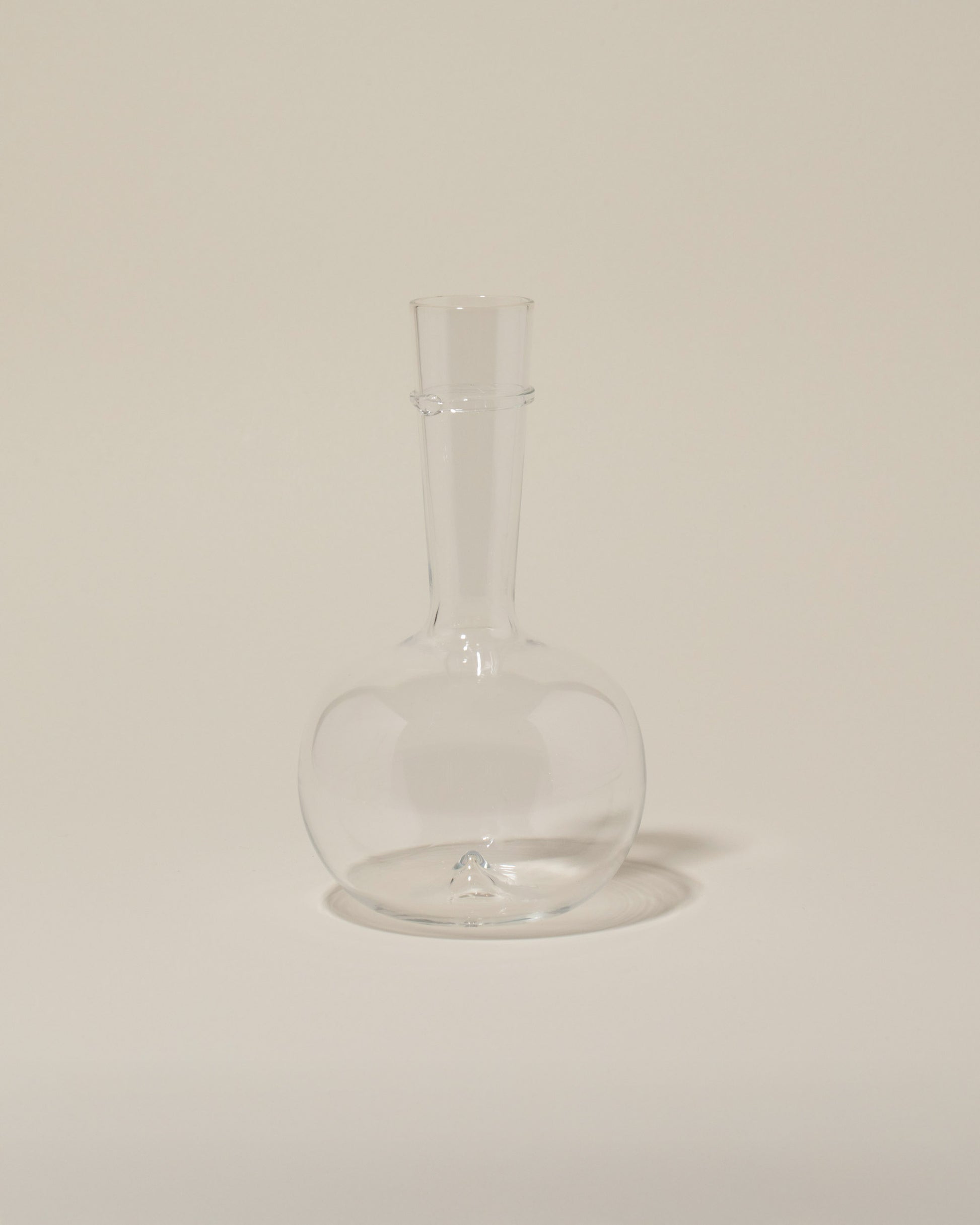 Bollenglass Design Clear Bud Vase on light color background.