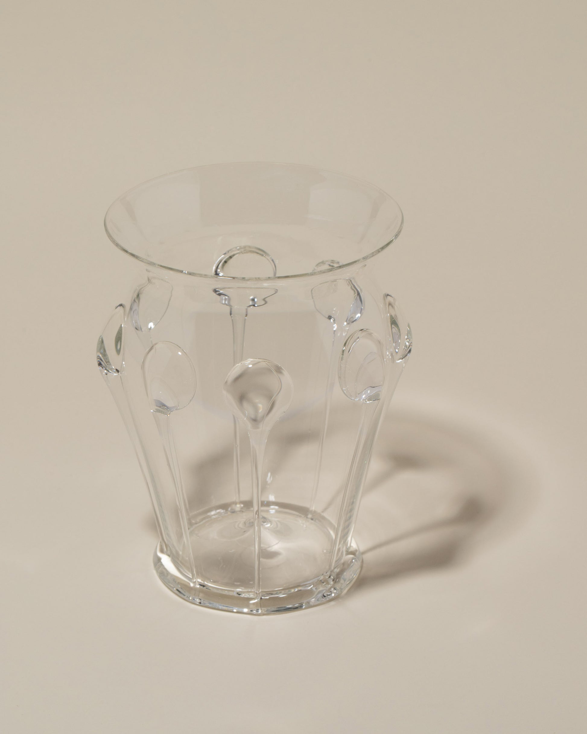 Closeup details of the Bollenglass Design Clear Drip Vase on light color background.