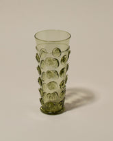 Closeup details of the Bollenglass Design Green Dot Water Glass on light color background.