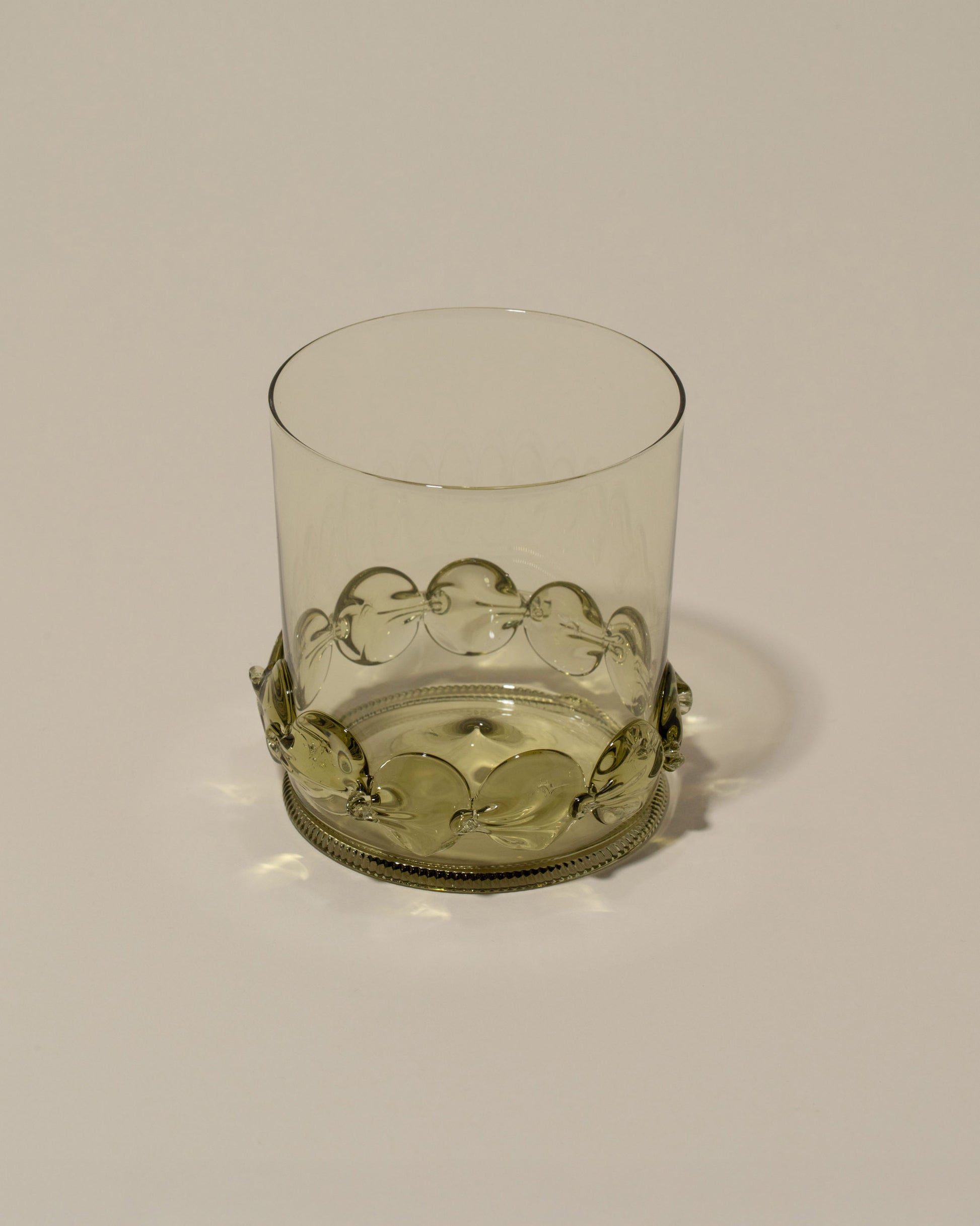 Closeup details of the Bollenglass Design Green Dot Whiskey Glass on light color background.