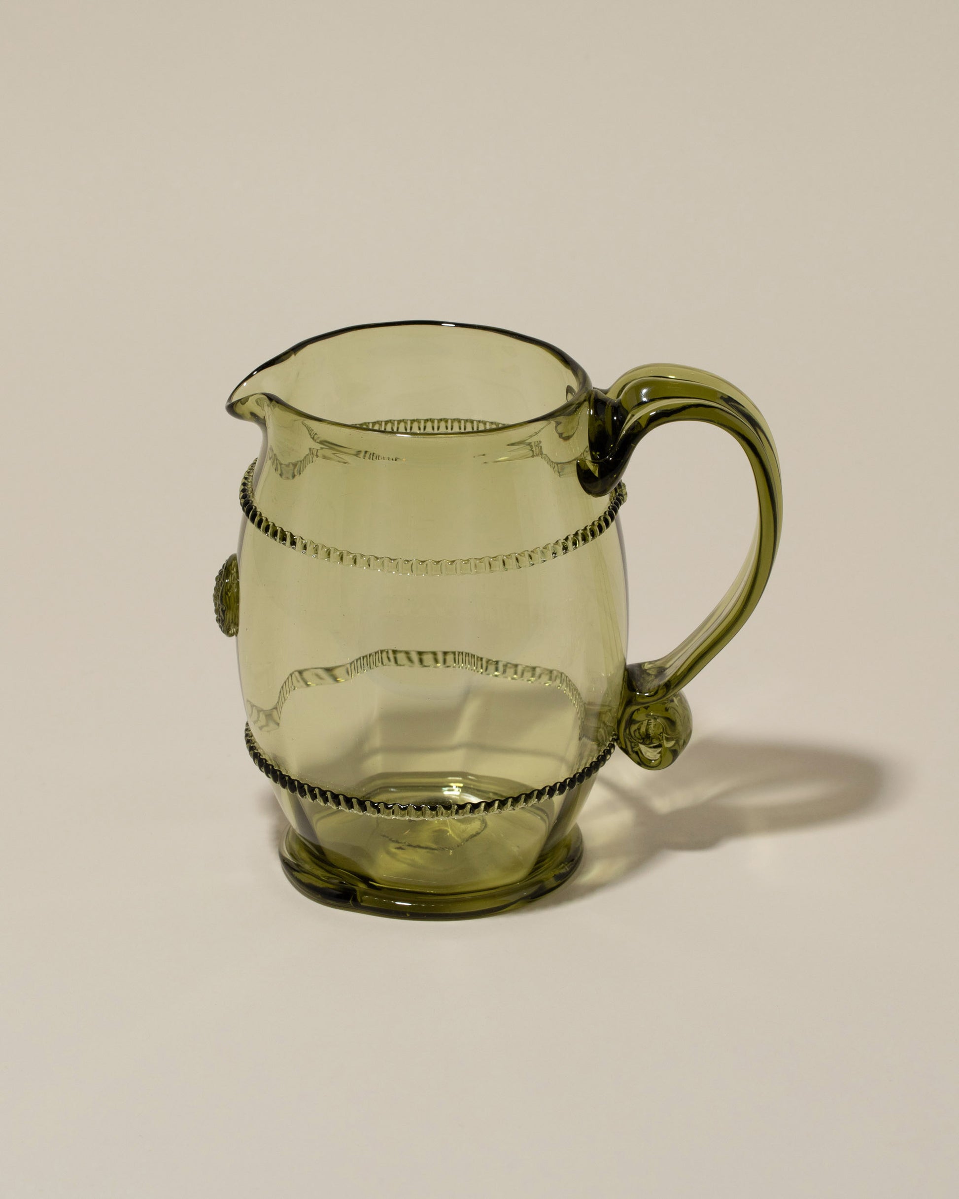 Closeup details of the Bollenglass Design Green Petite Pitcher on light color background.