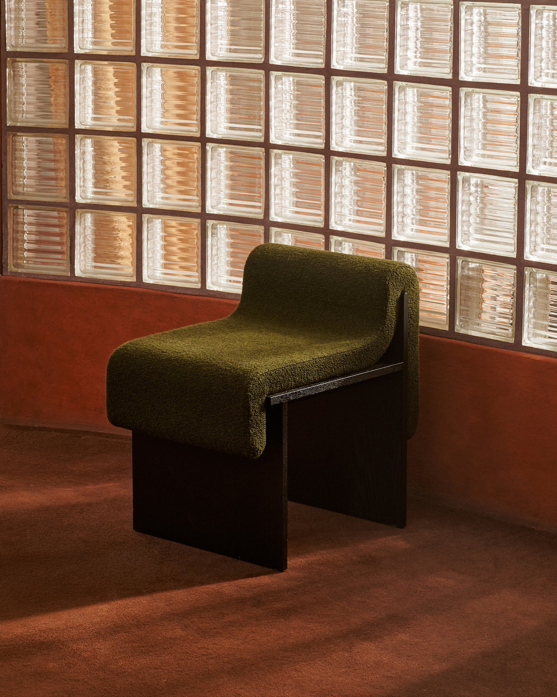 The Bower Studios Low-Back Melt Accent Chair in blackened oak upholstered with Maharam
Hearth in Downfield in front of accent wall.