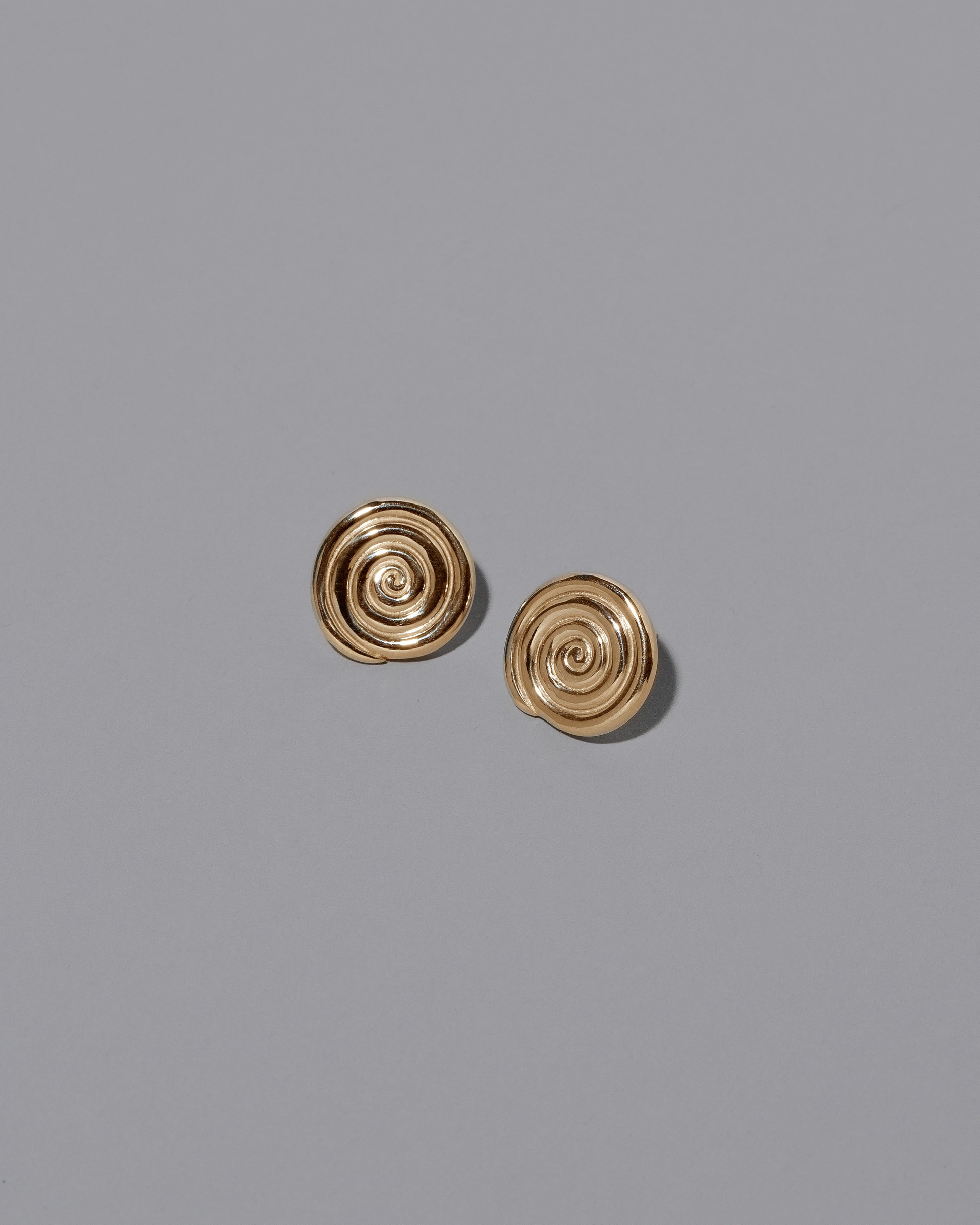 CRZM 22k Gold Serpentinite Stud Earrings on light color background.