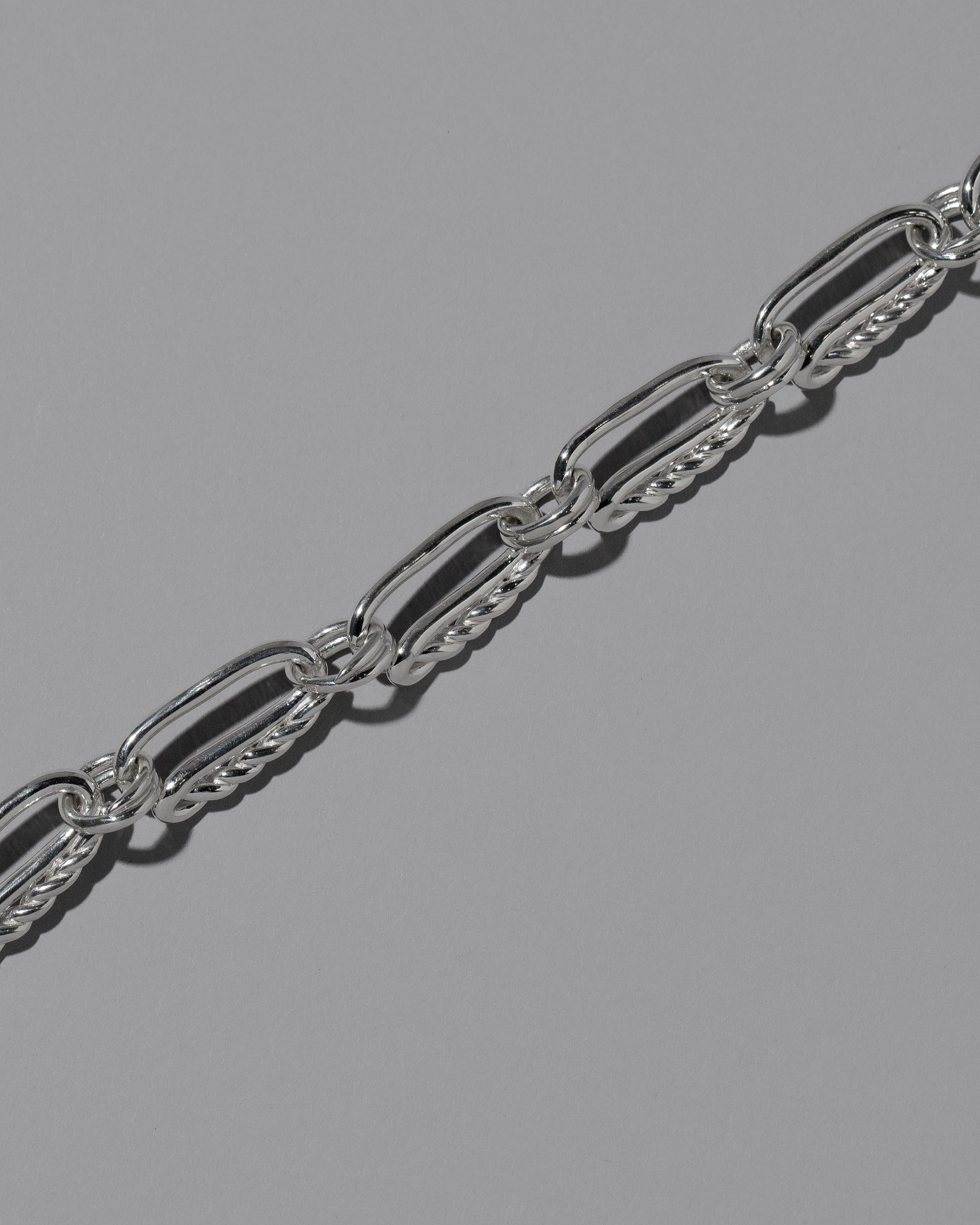 Closeup details of the CRZM Sterling Silver Ophiolite Bracelet on light color background.