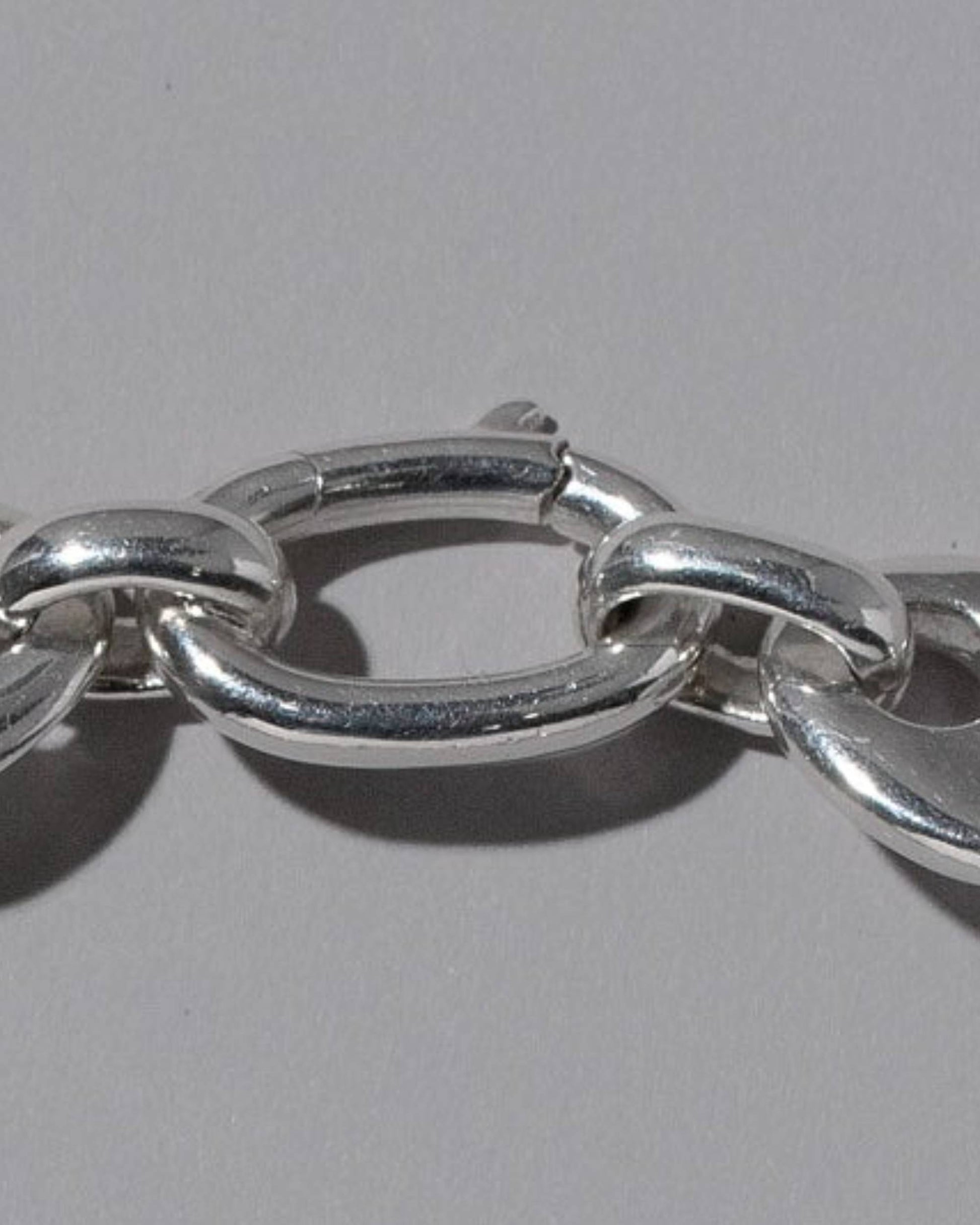 Closeup details of the CRZM Sterling Silver Oval Lobster Clasp on light color background.
