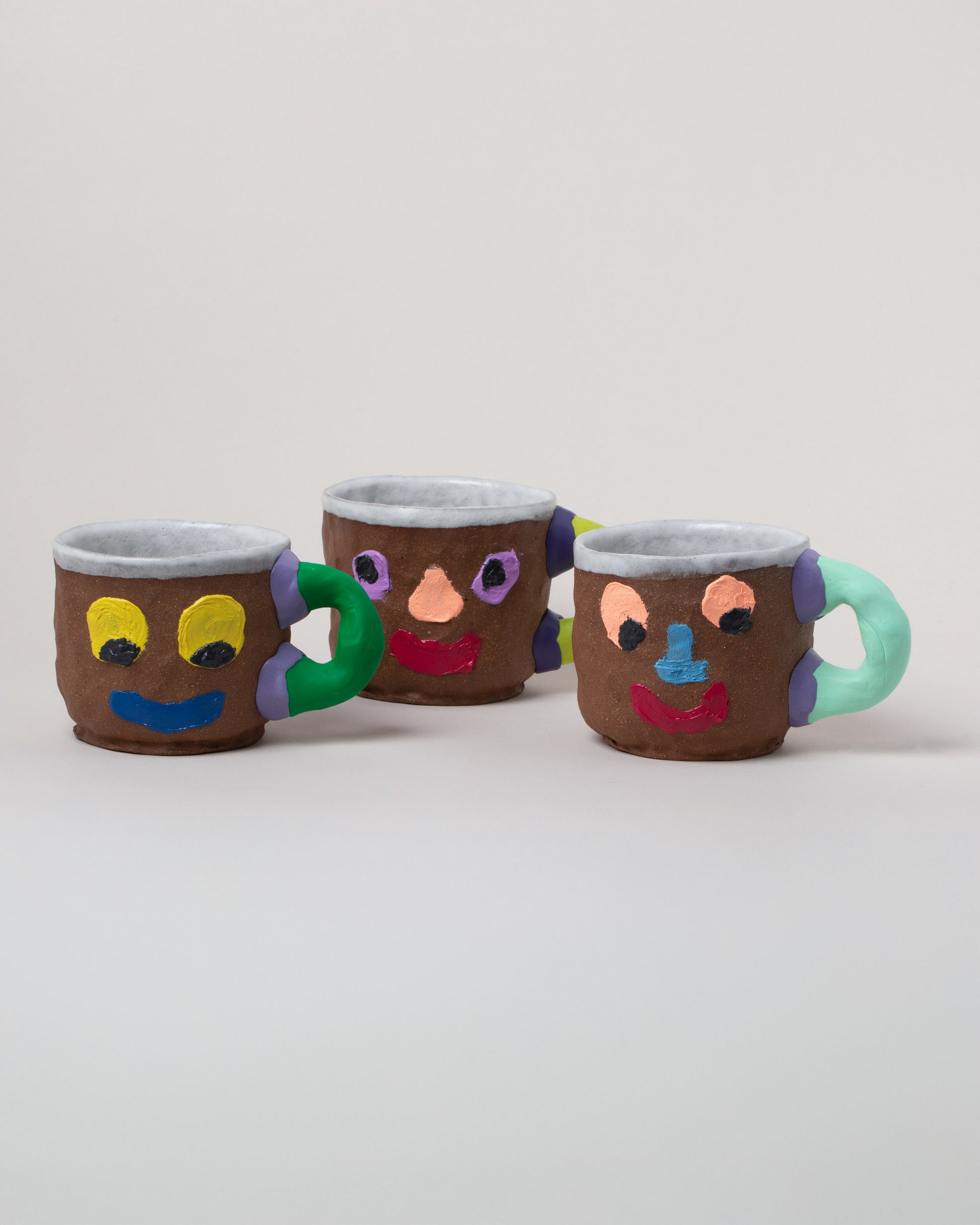 Ceramicism Kool-Aid™ Face Mugs on light color background.